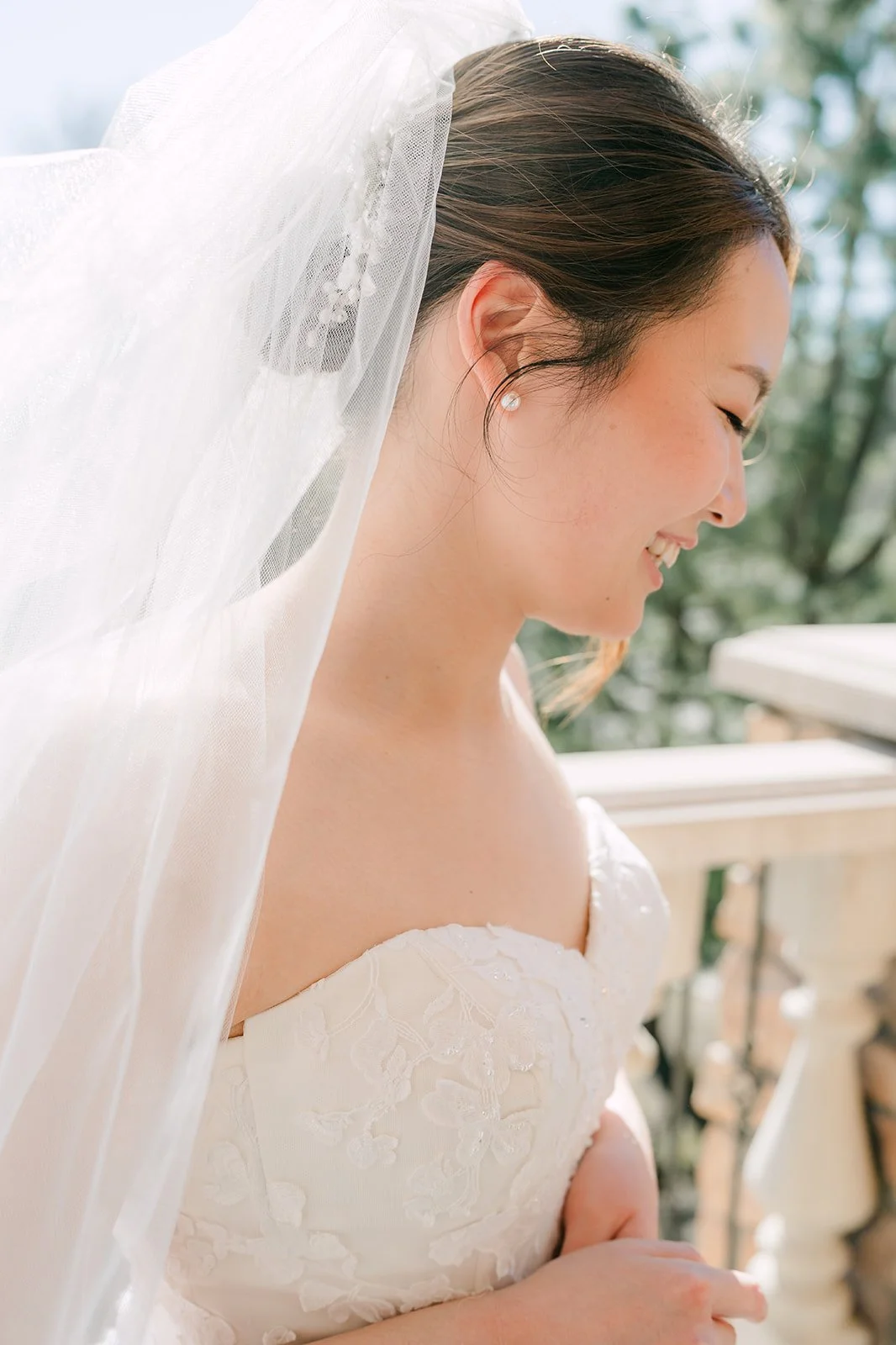 Soft profile portrait of the bride in her cathedral veil