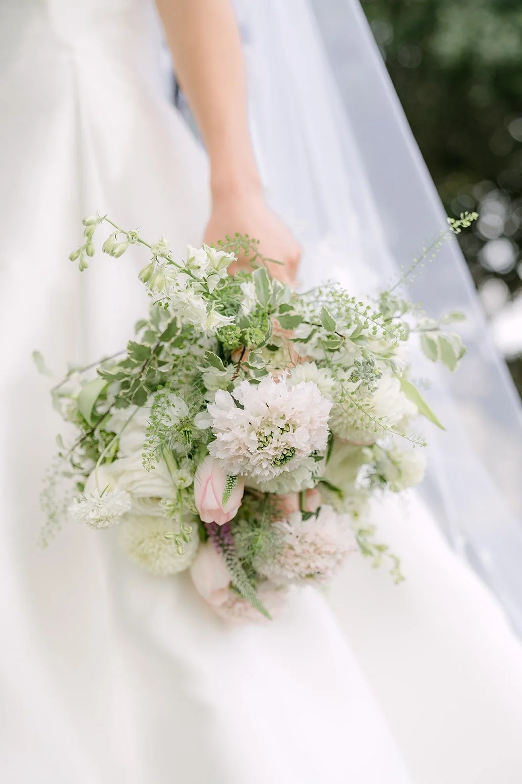 Kristine's blush and ivory bouquet held against her gown