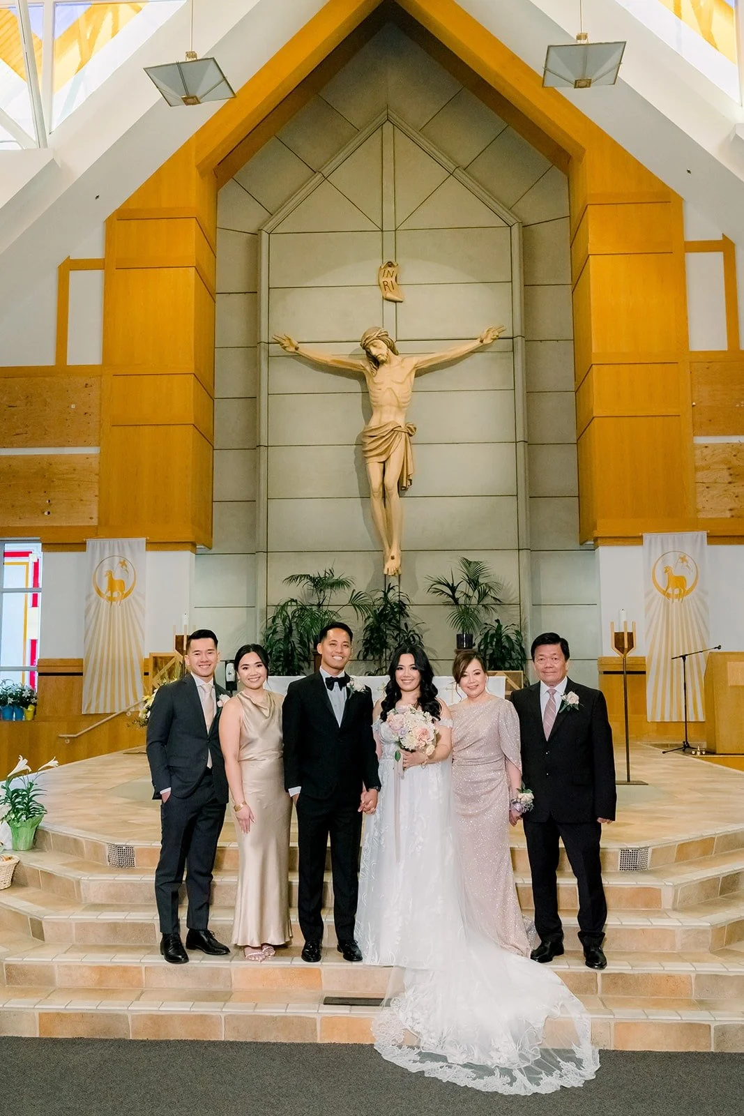 Francesca and Ralph with family in front of the altar at St. Paul the Apostle Catholic Church, photographed by One and Only Production
