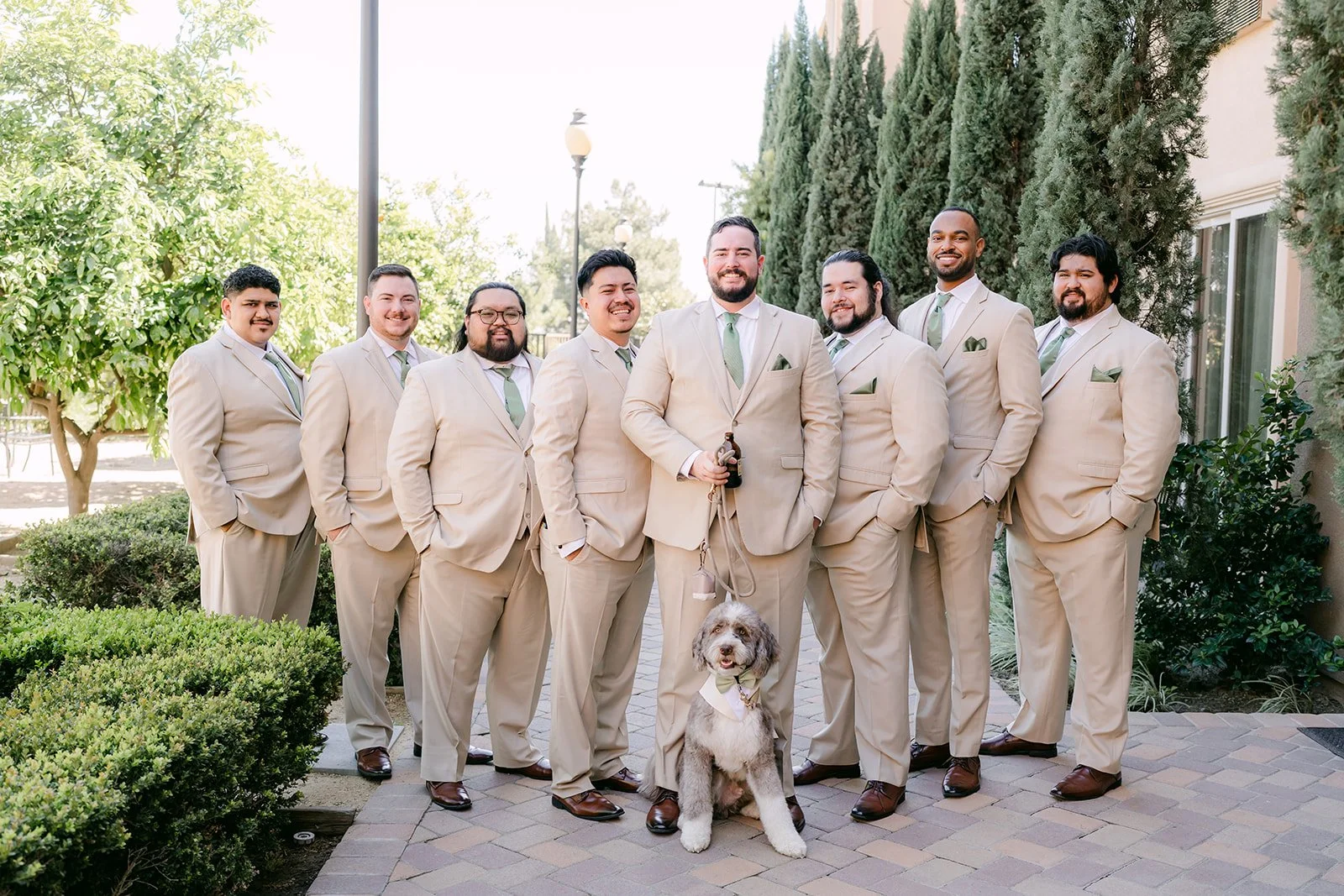 Cody and his groomsmen in matching tan suits outside the hotel.