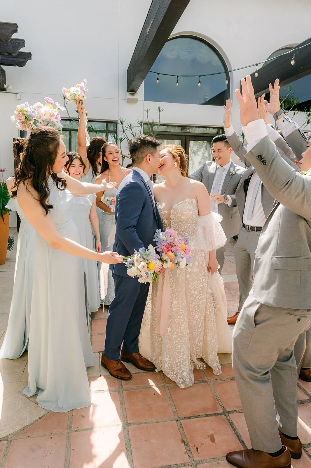 The wedding party celebrating around Joanna and Jerrick in the courtyard