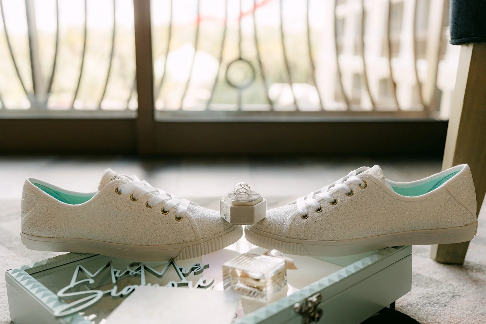 White sneakers and wedding rings styled by the window of the suite, photographed by One and Only Production