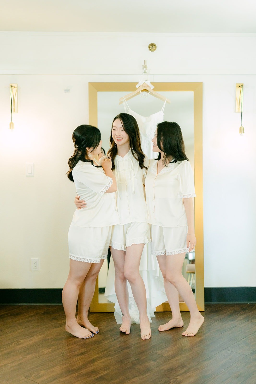 Tin laughing with her bridesmaids in white robes
