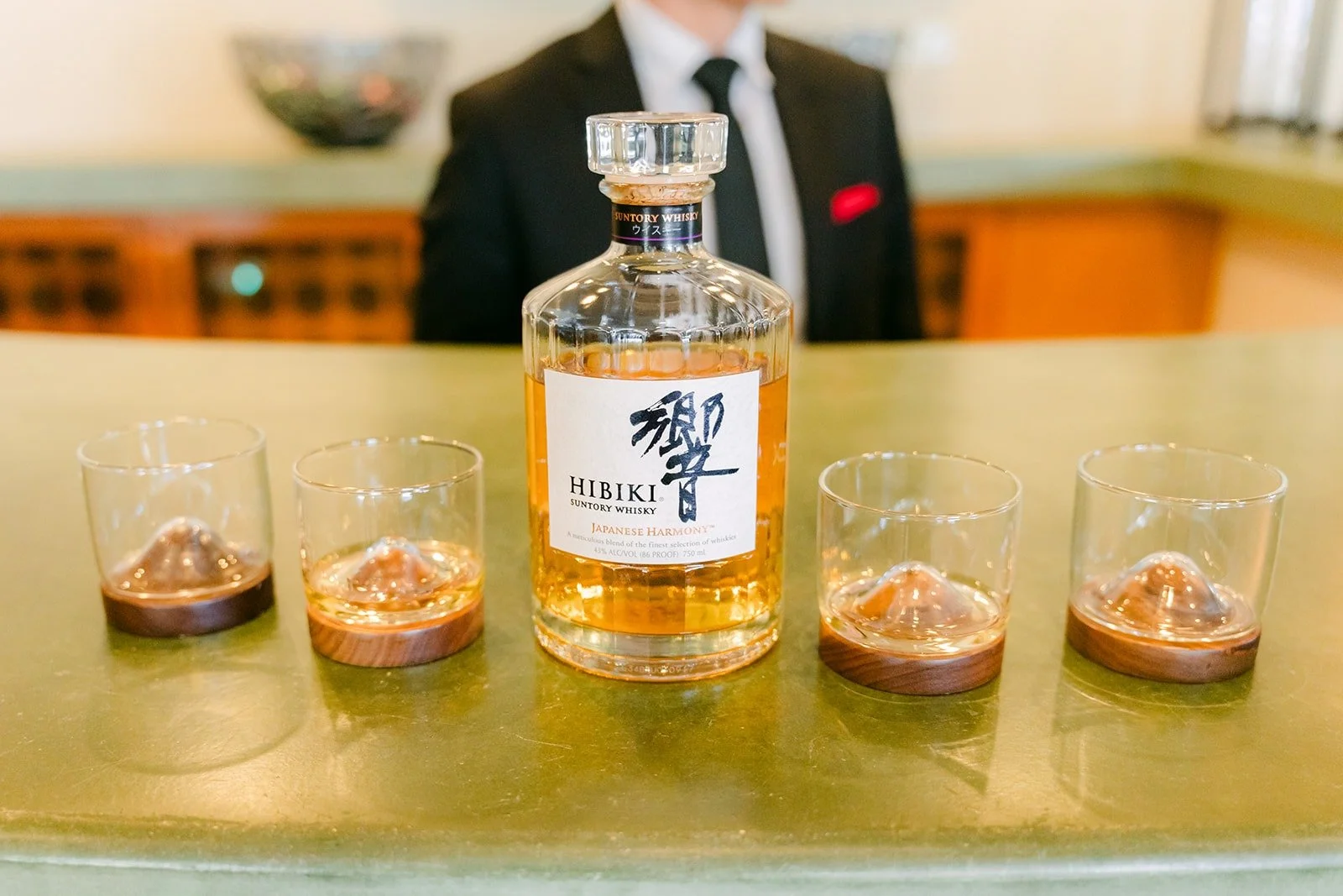 A bottle of whiskey and glasses set out for the groomsmen