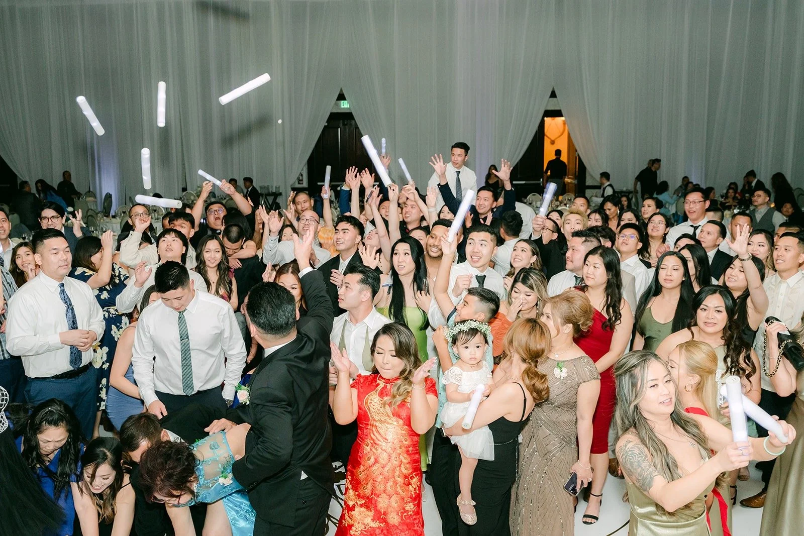 A packed dance floor with glow sticks in the air