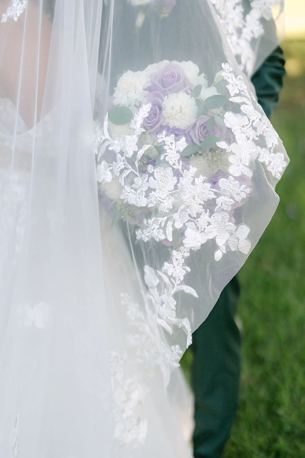 Lace detail of Jennifer's veil with her bouquet in soft focus, photographed by One and Only Production