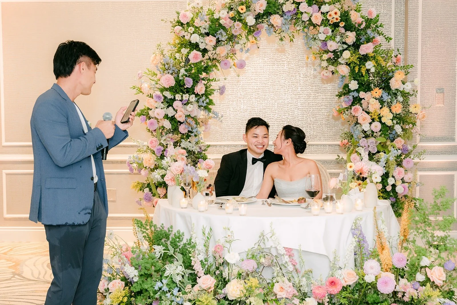 A family member giving a toast beside the sweetheart table, photographed by One and Only Production