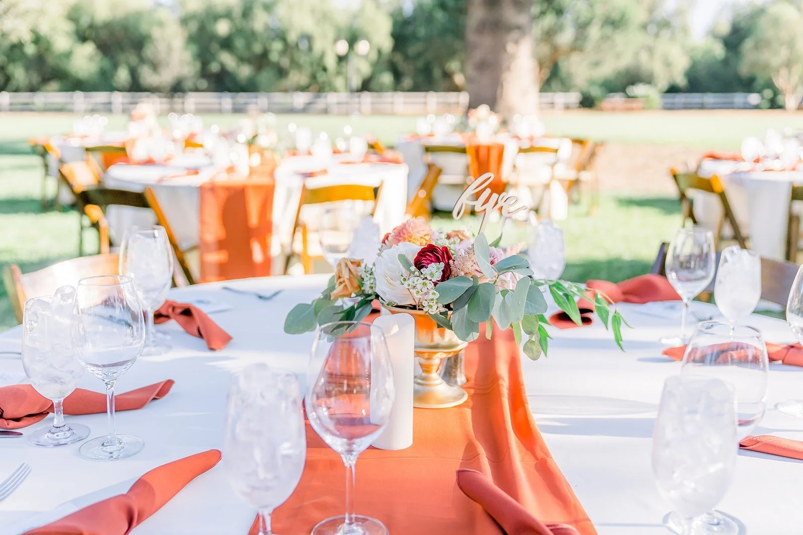 Reception place settings with orange napkins