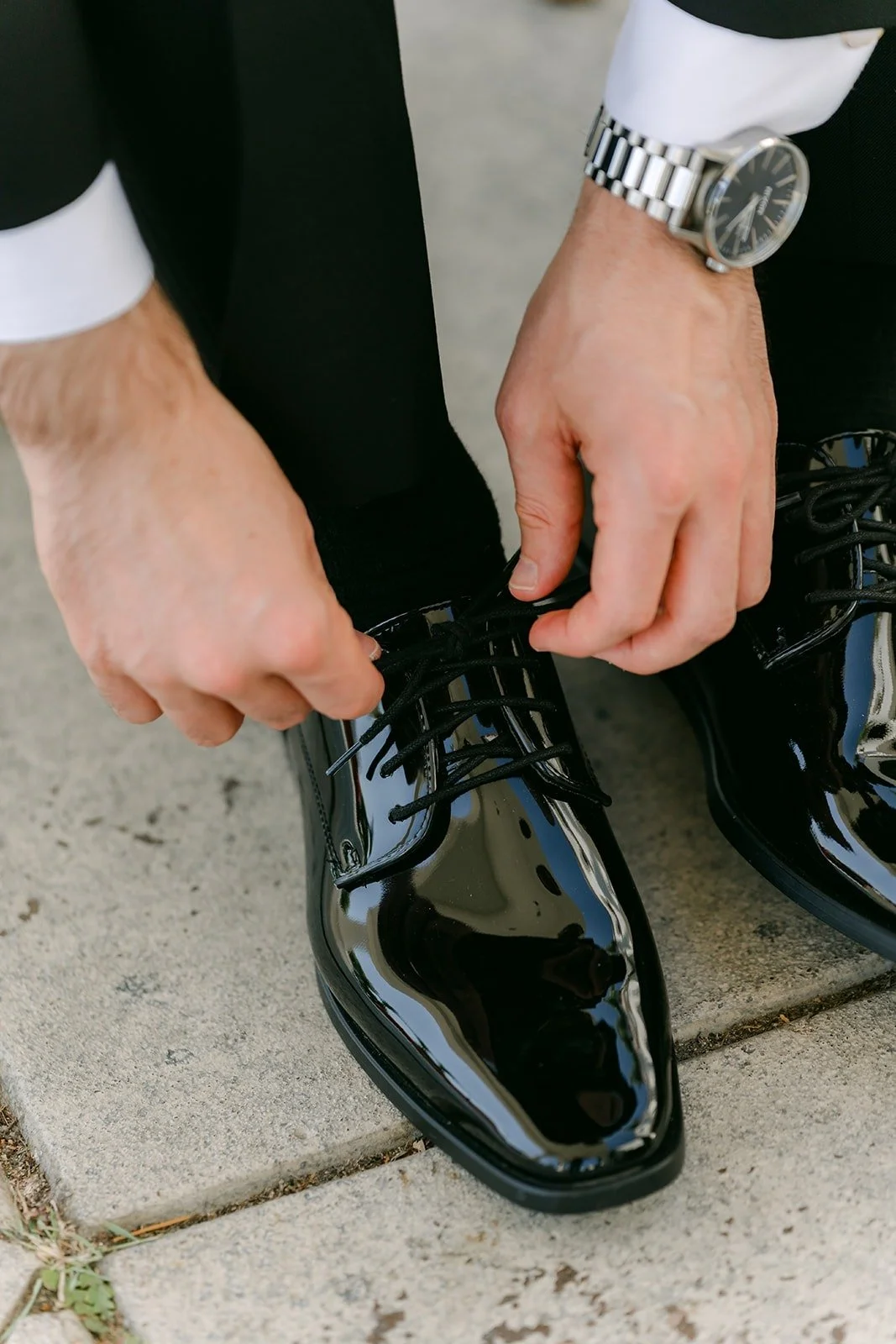 Kevin tying his polished black dress shoes
