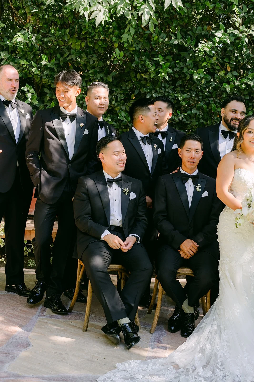 Caryl and his groomsmen in black tuxedos with Nicole at Eden Gardens.