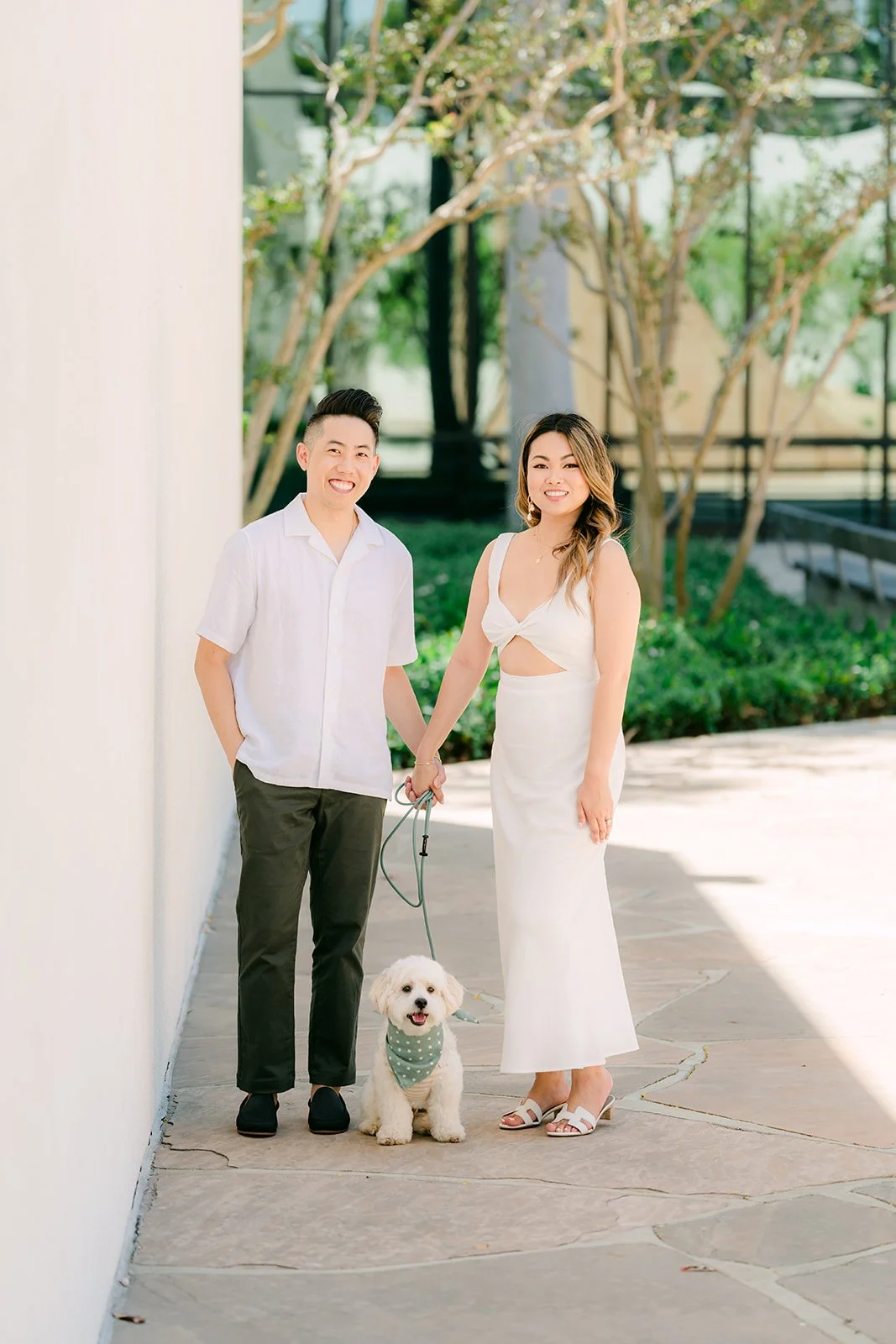 Stephanie, Alan and Tofu standing along the white wall.