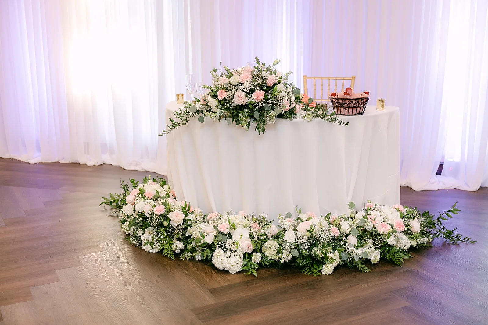 Sweetheart table wrapped in white and blush flowers