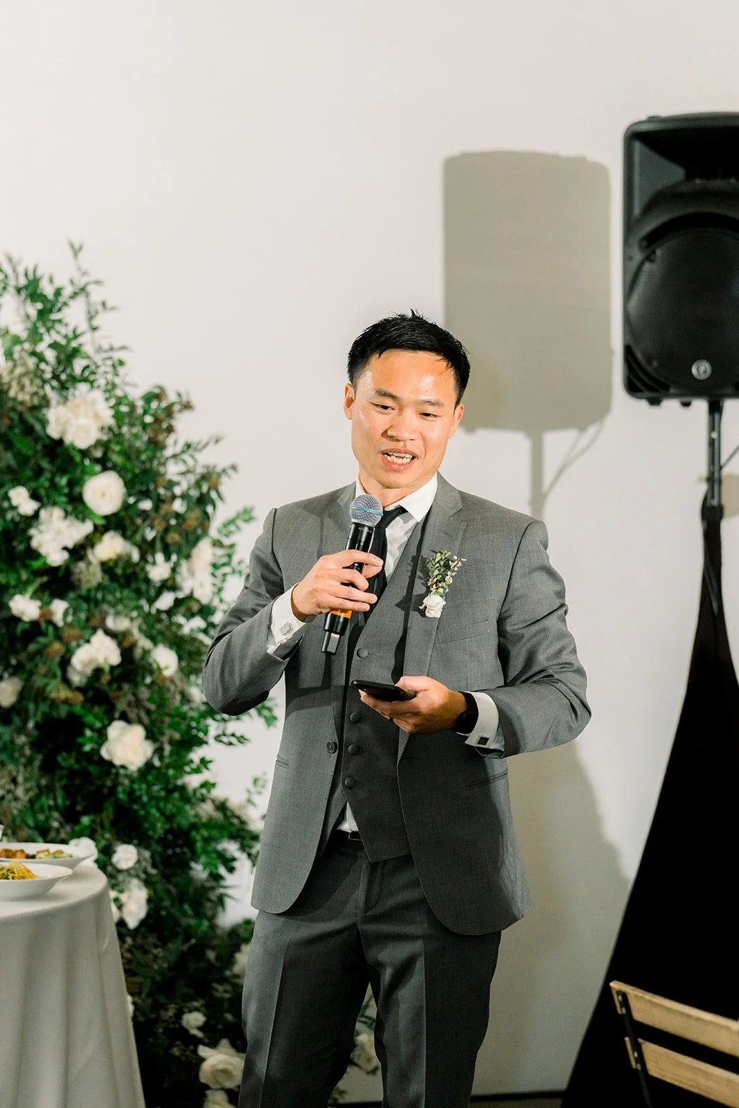 A groomsman speaks into the microphone