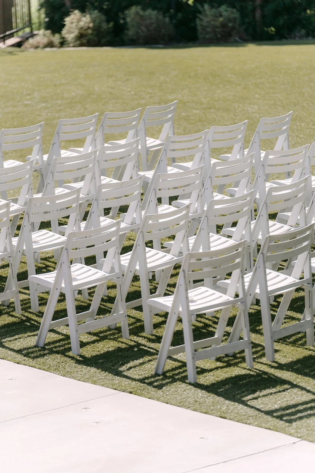 White ceremony chairs on the lawn