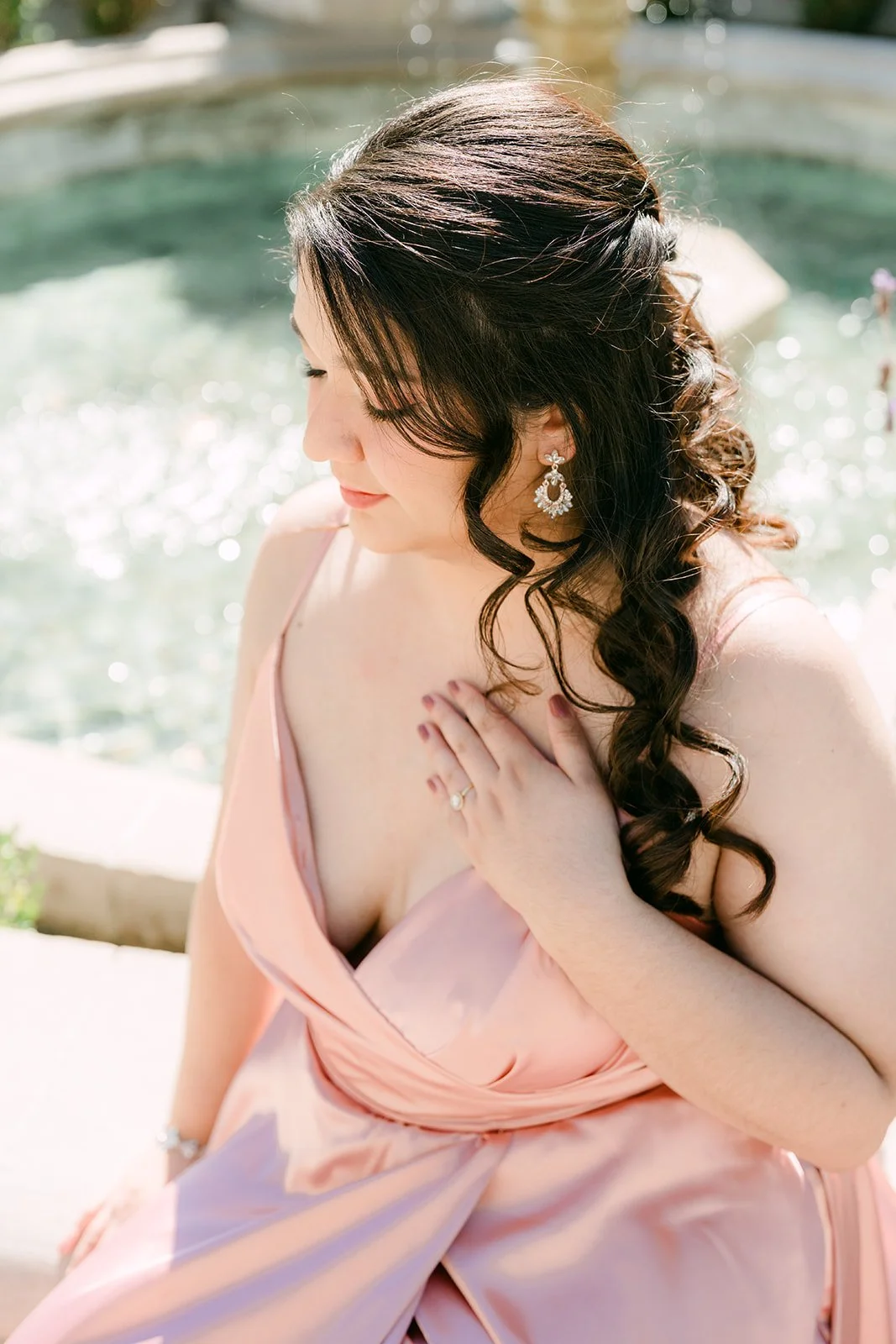 Saira seated at the motor court fountain, her curls over her shoulder.