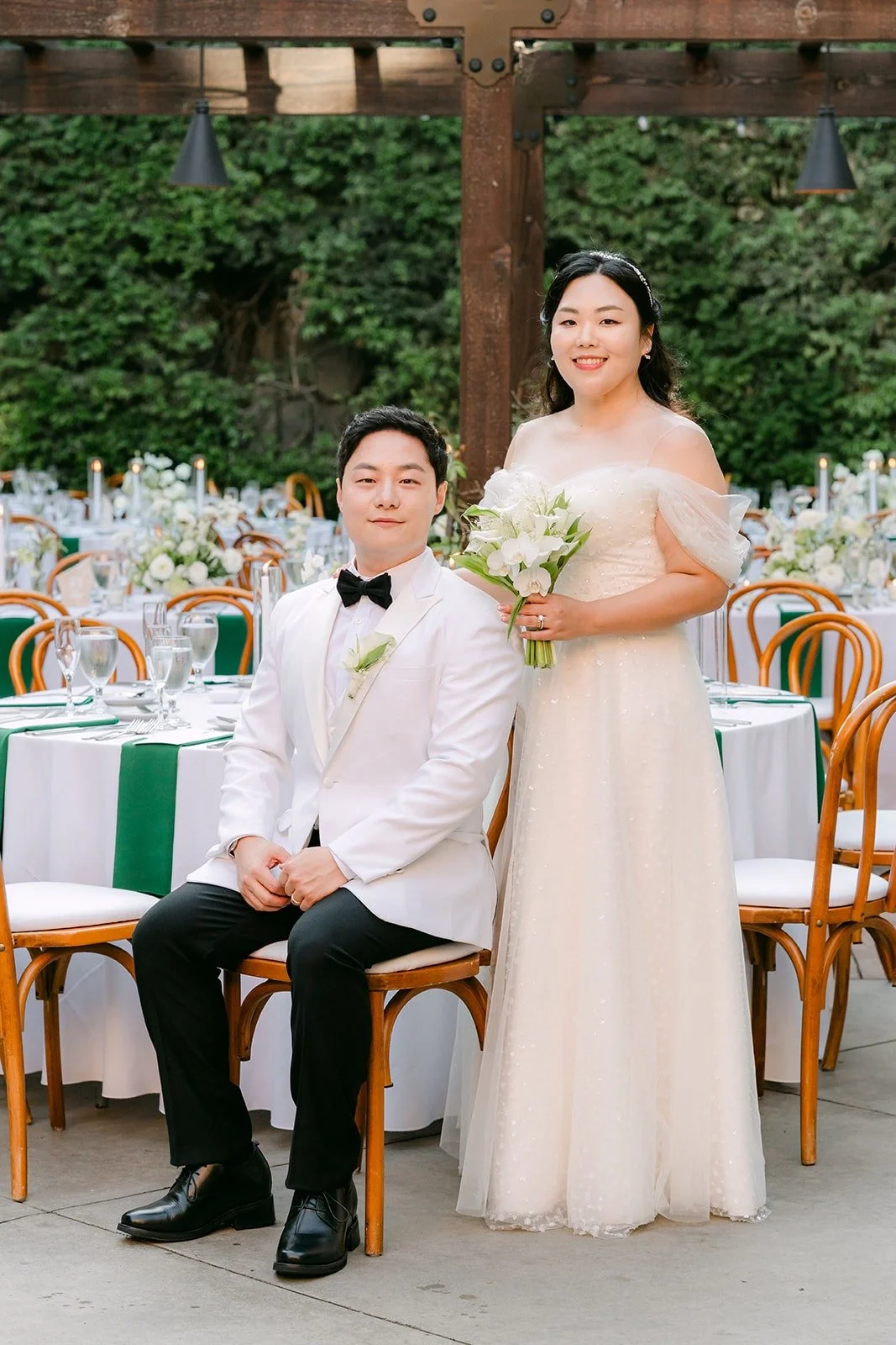 Chorok and Min Soo seated together among the reception tables in their second looks
