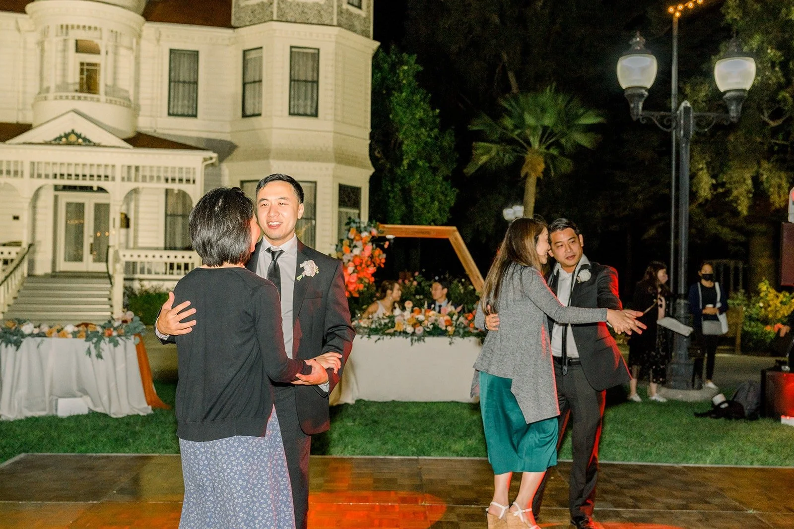 Guests dancing on the outdoor floor in front of the house