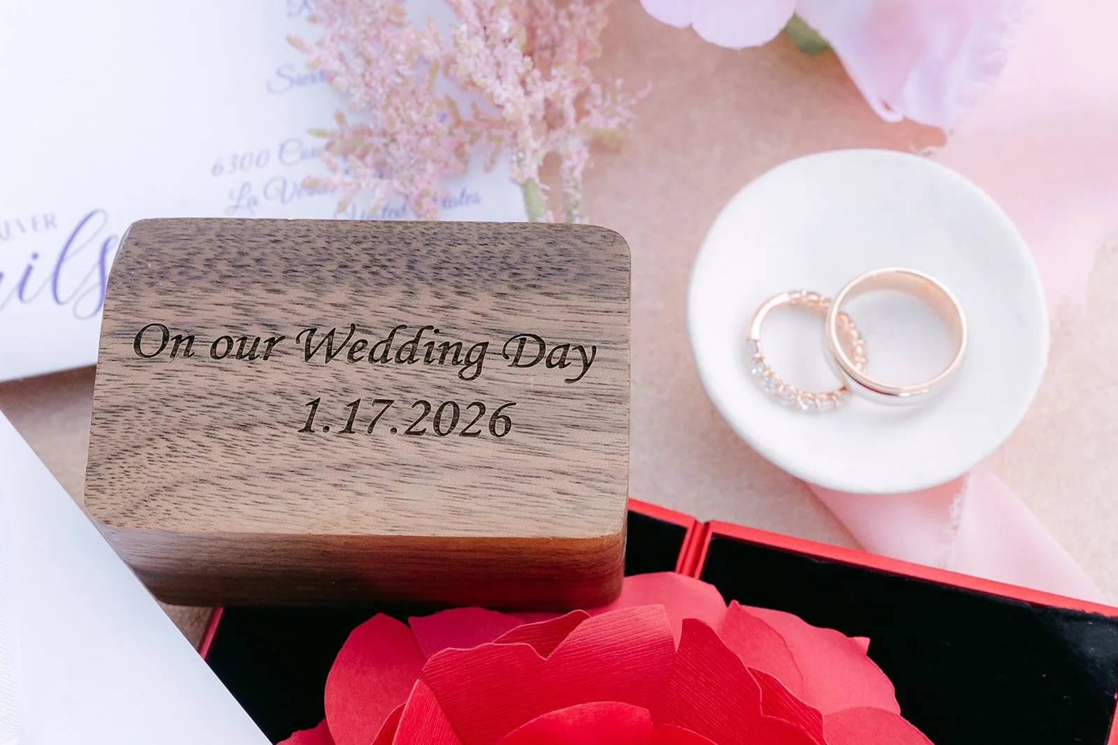 An engraved wooden ring box with Kate and Michael's wedding date and their rings.