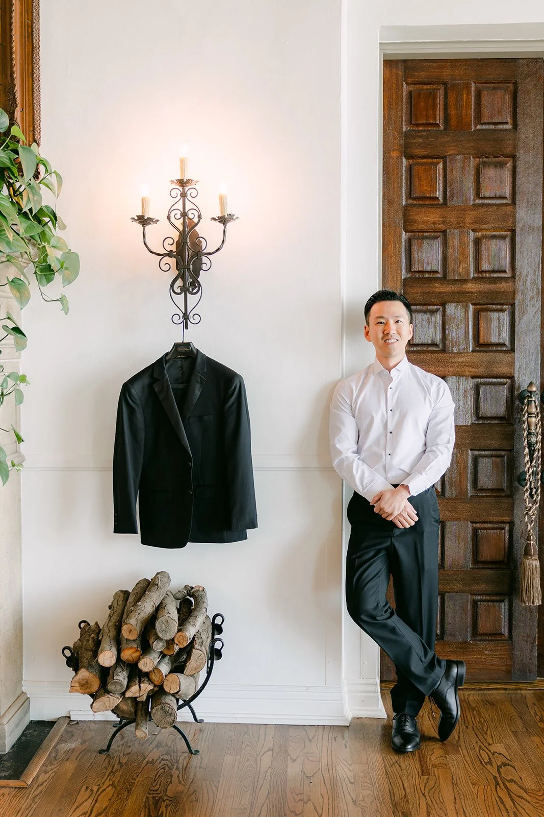 Kai leaning beside his tuxedo in the groom suite at Bel-Air Bay Club