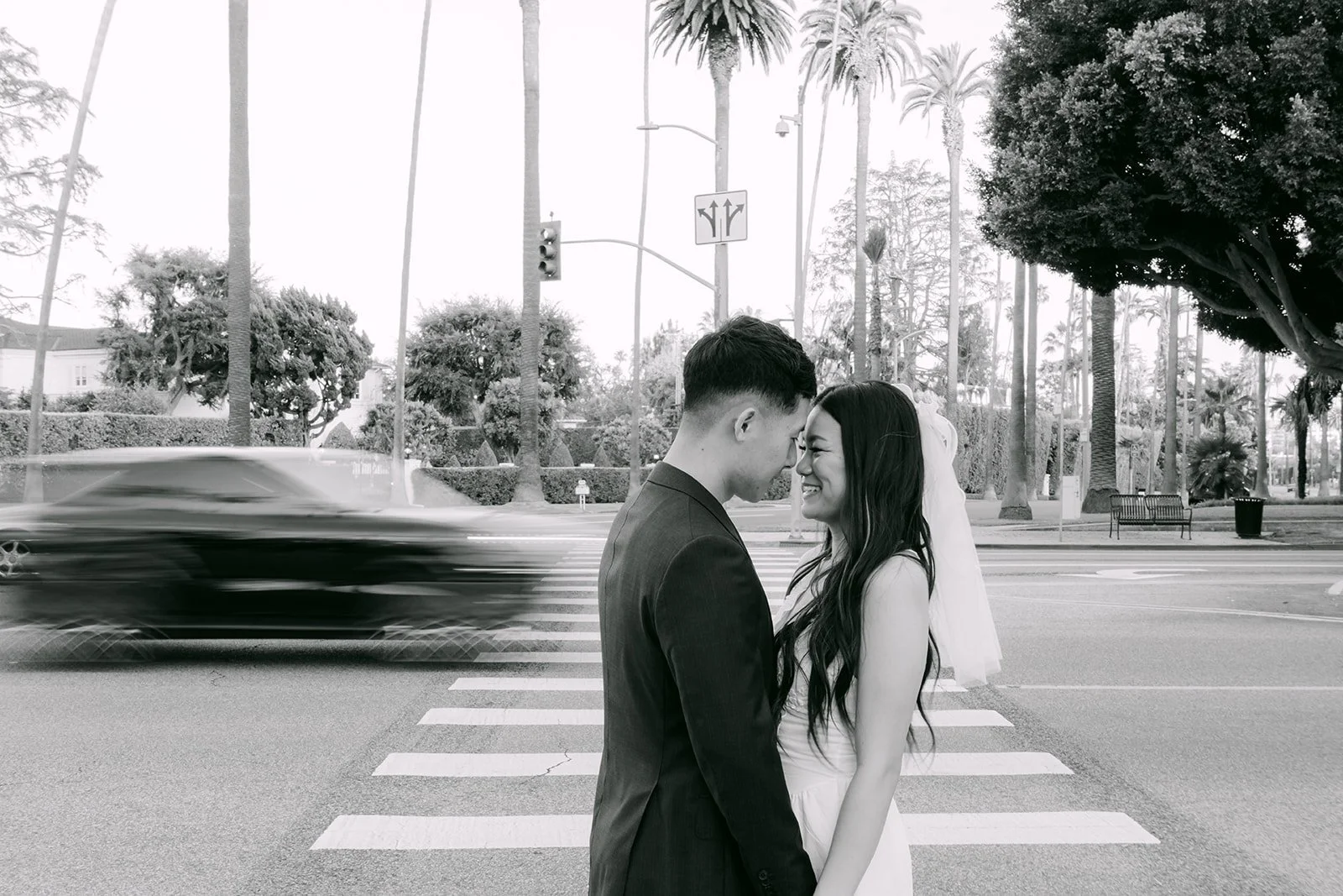 Black and white photo of Jadee and Richard kissing as traffic blurs past.