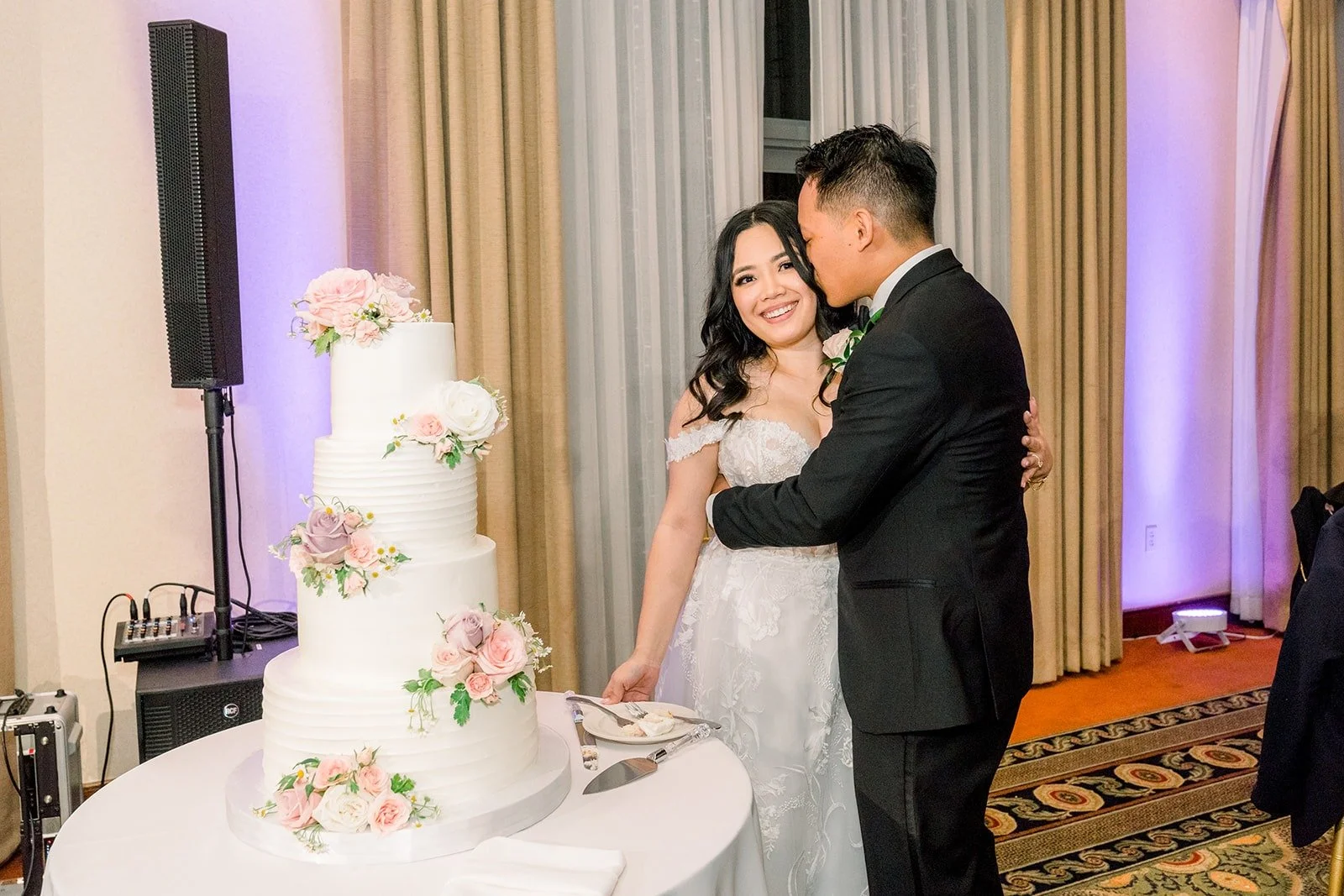 Francesca and Ralph laughing at the cake table, photographed by One and Only Production