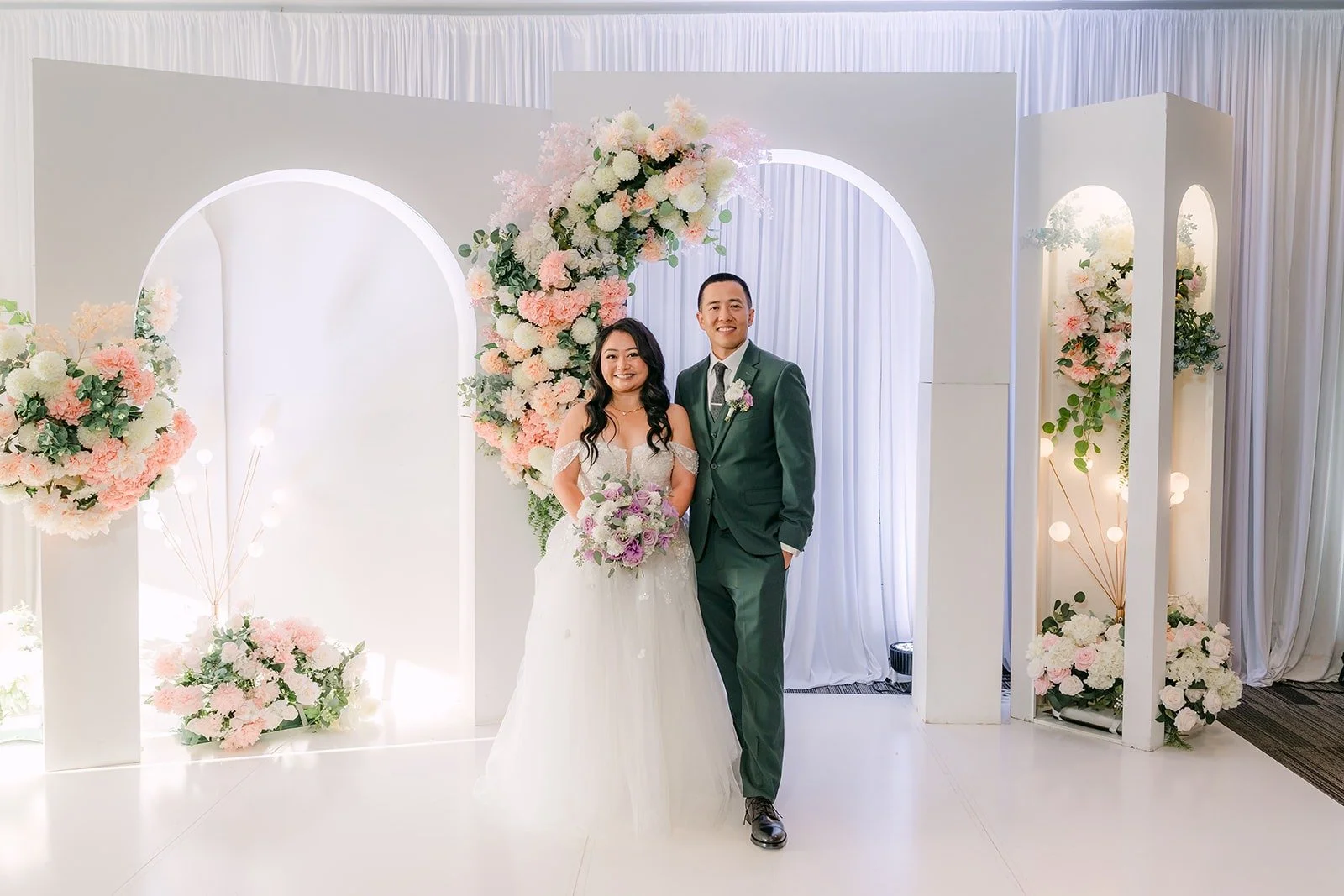 Jennifer and Kevin at the white arch with pink and white florals