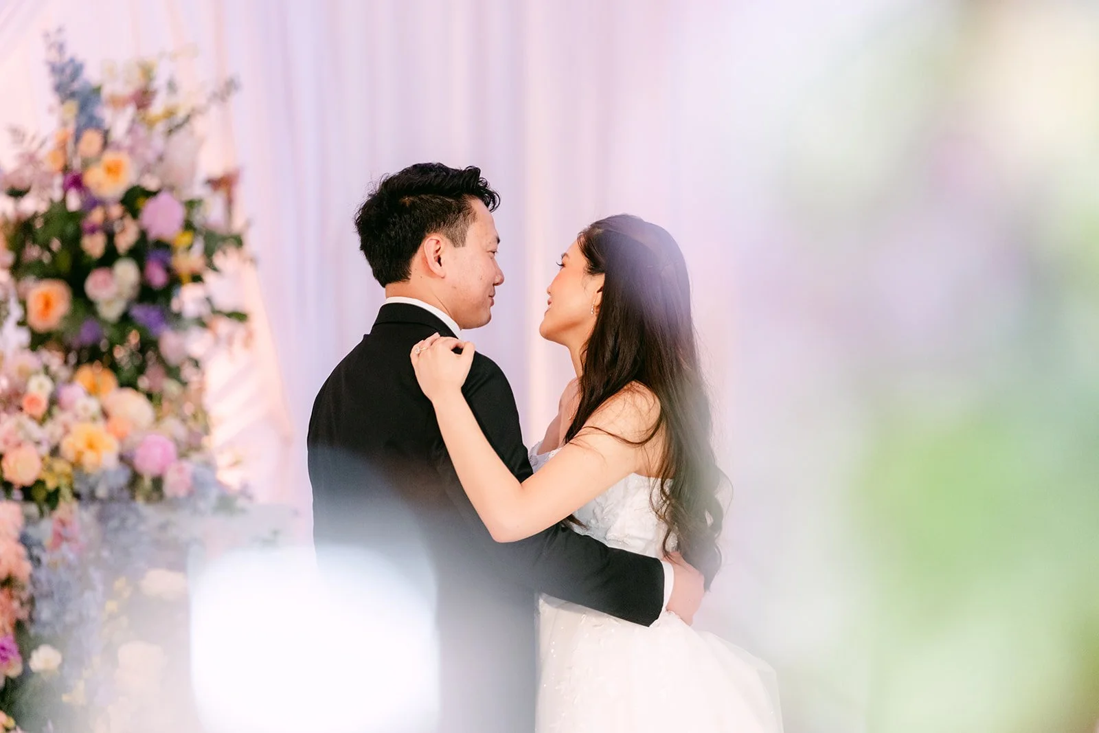 Hoan and Linh smiling at each other during their first dance