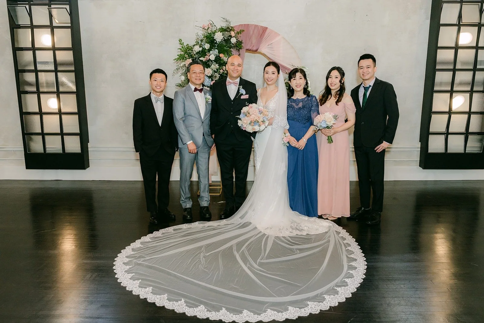 Elisa and Brandon with family in front of the ceremony arch