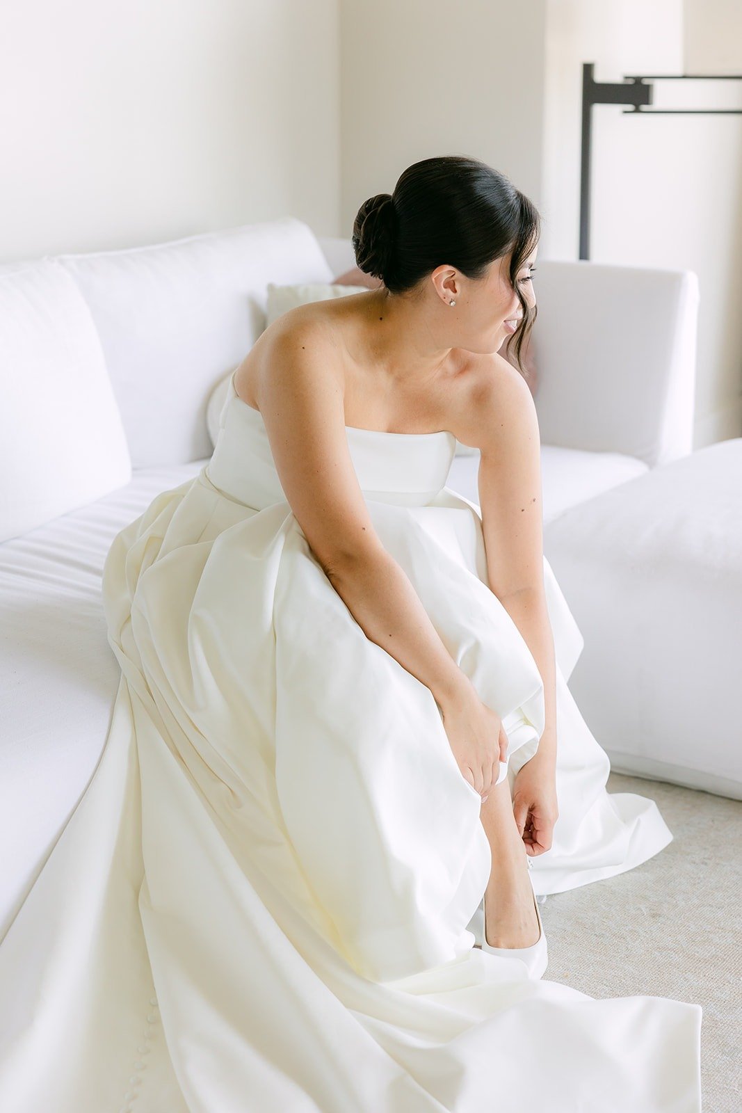 Brianna slipping on her shoes in her strapless gown