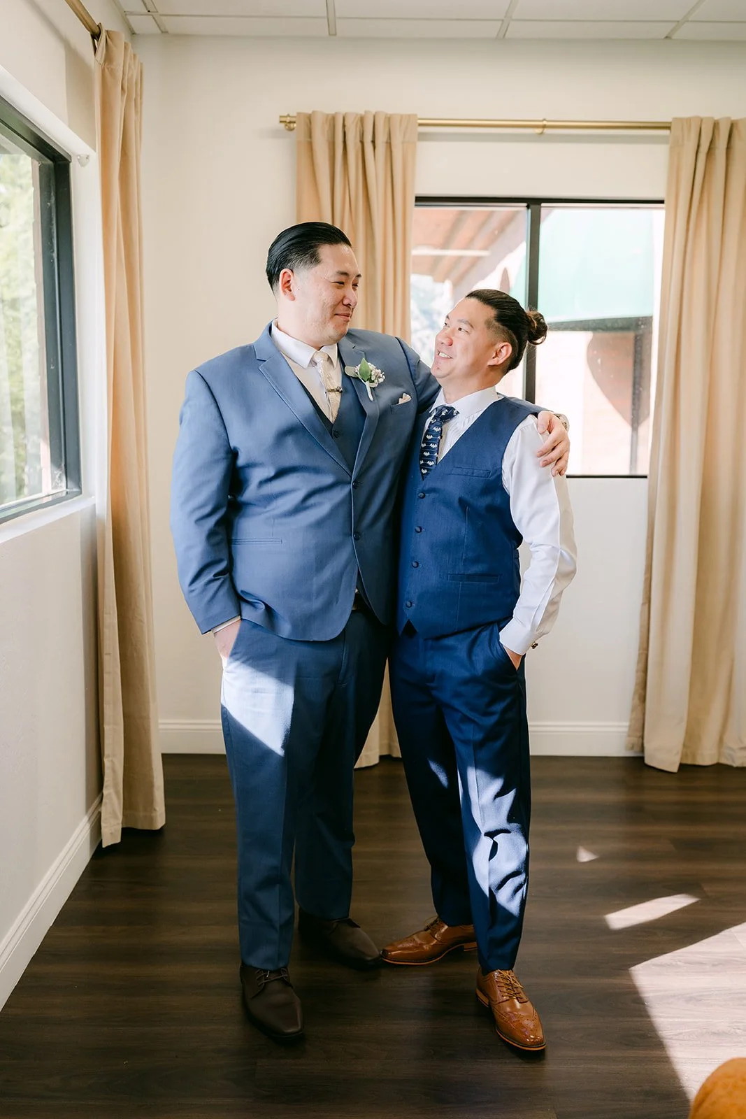 Michael and a groomsman in navy suits getting ready.