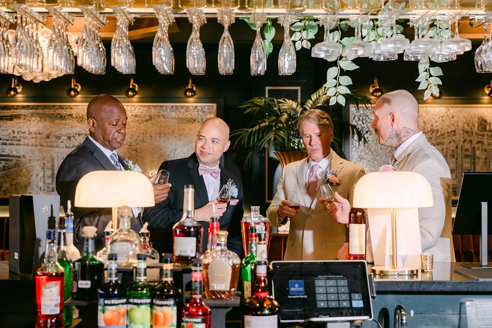 Brandon and his groomsmen pour drinks at the bar before the ceremony