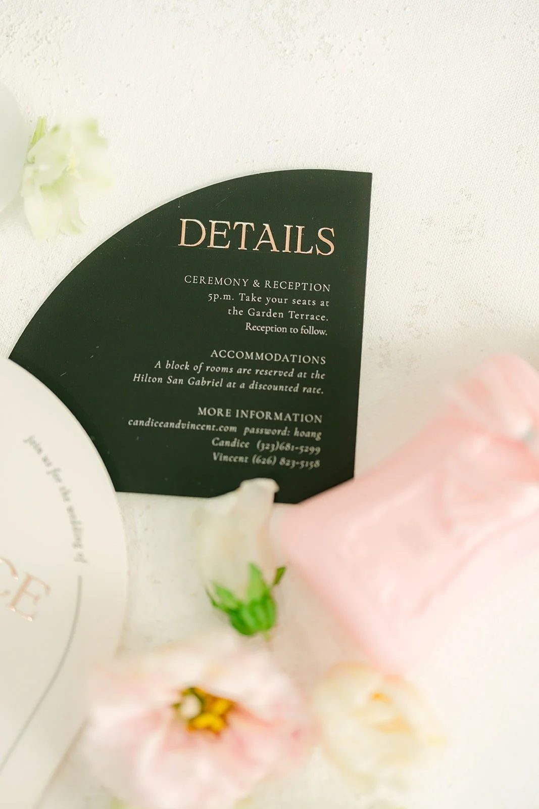 Black arch details card and pink perfume bottle from the invitation suite