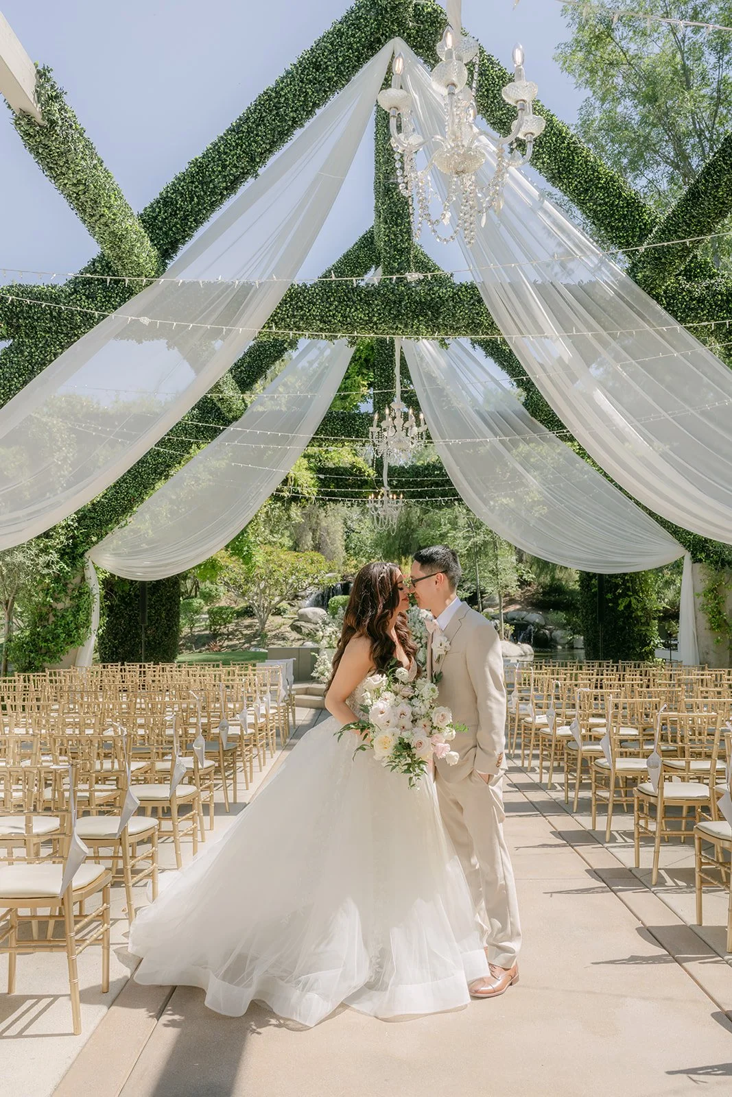 Sandra and Kevin kissing under the draped ceremony pergola.