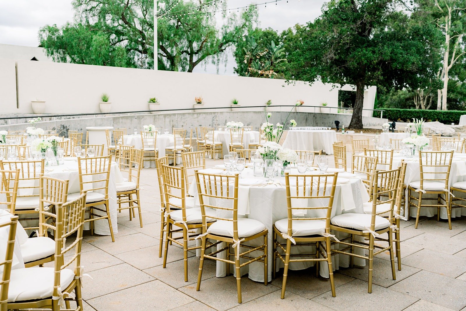 Reception tables with gold chairs set on the patio