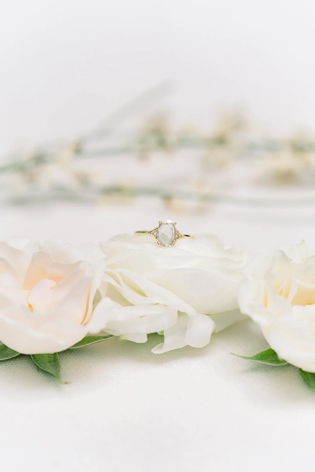 Cindy's engagement ring resting on white roses