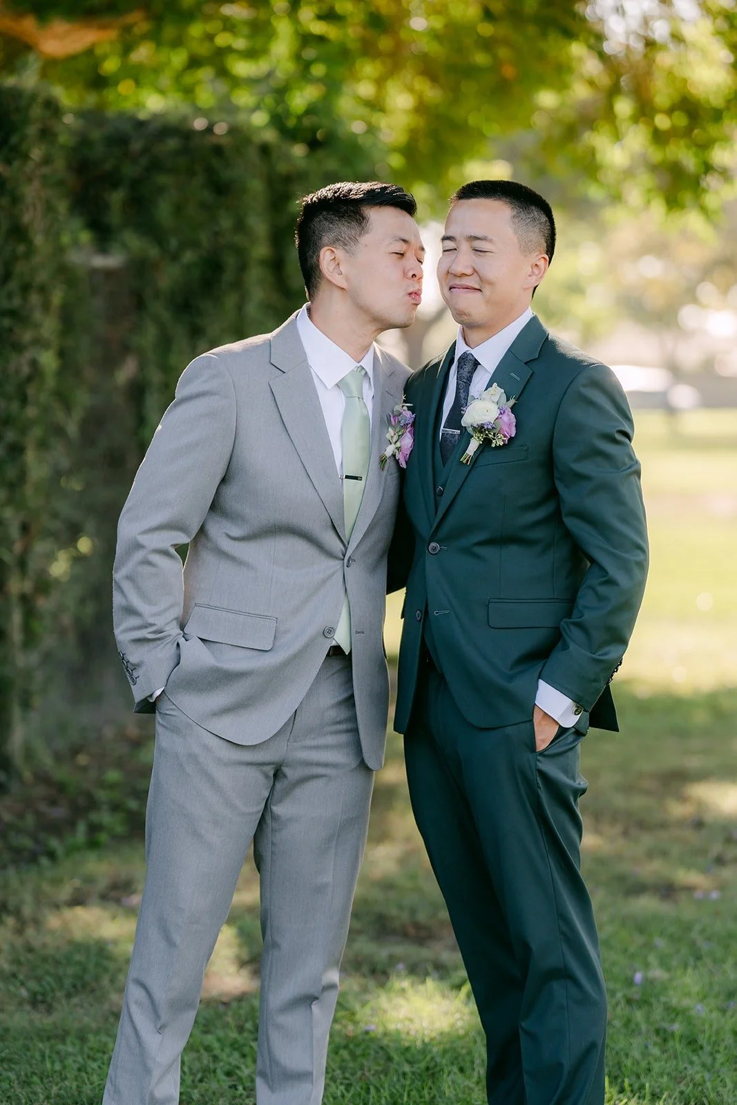 Kevin and a groomsman lean in for a cheek kiss