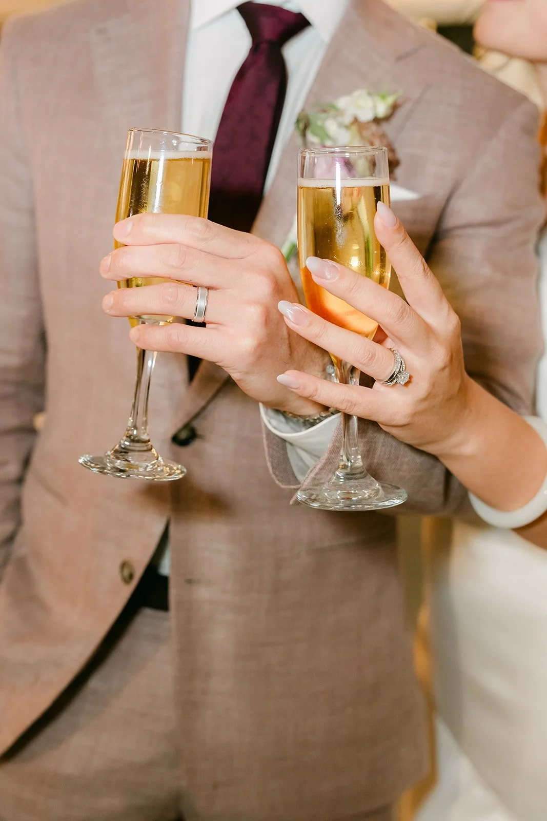 Close-up of champagne glasses against Michael's blush suit.