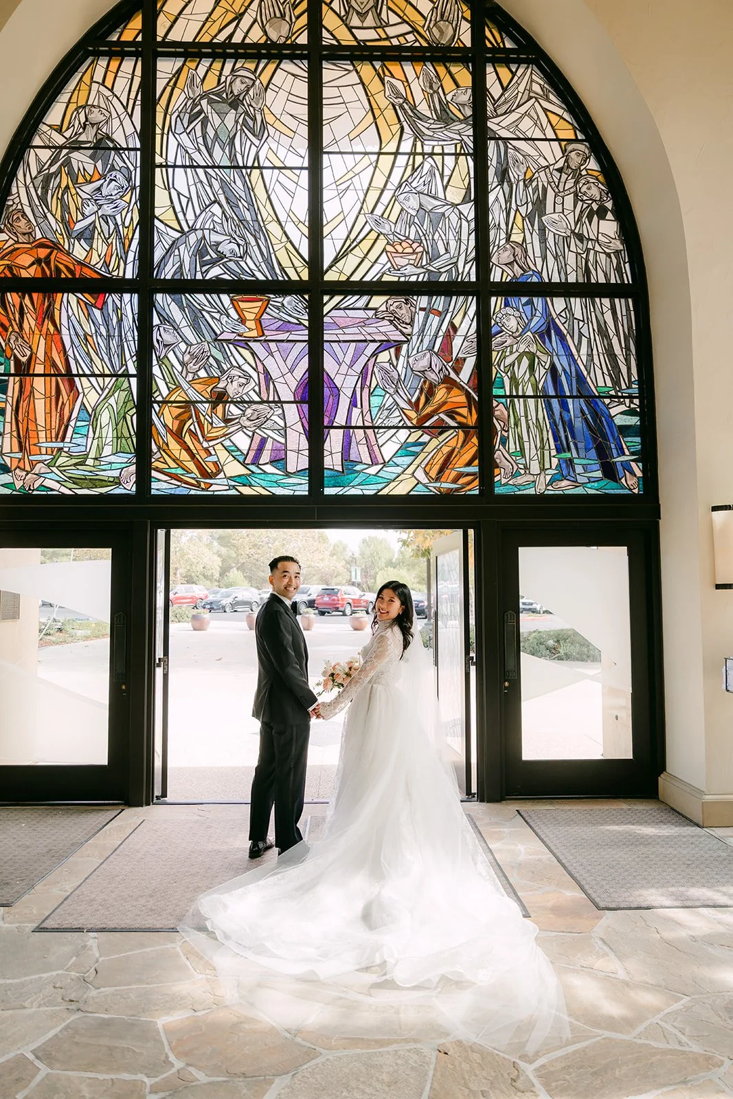 Kim and Vincent under the stained glass windows at St. John Fisher Church
