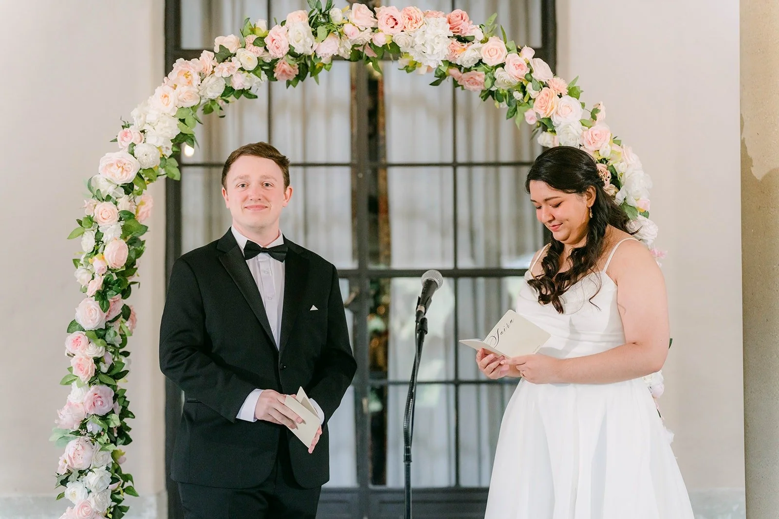 Matthew and Saira under the rose arch at the start of their self officiated ceremony
