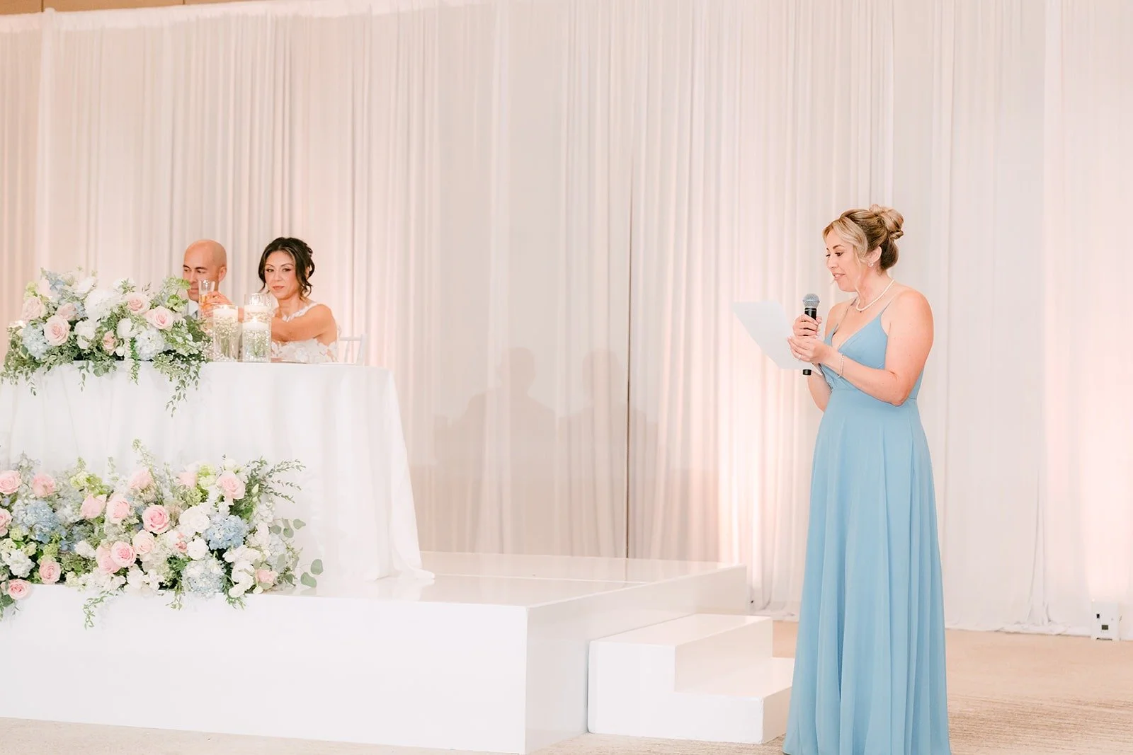 A bridesmaid shares a toast from the dance floor