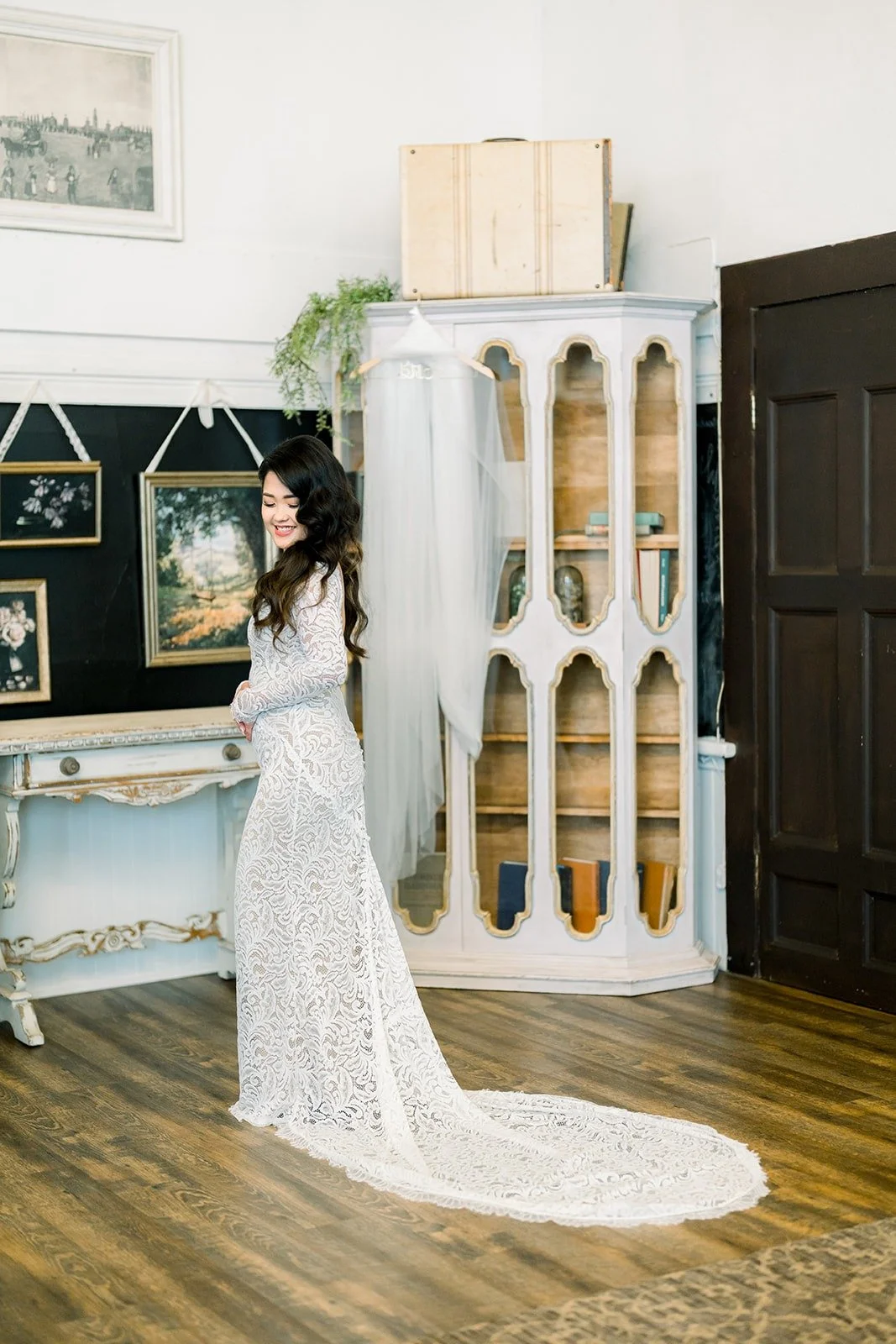 Hannah in her lace gown with her train spread across the floor