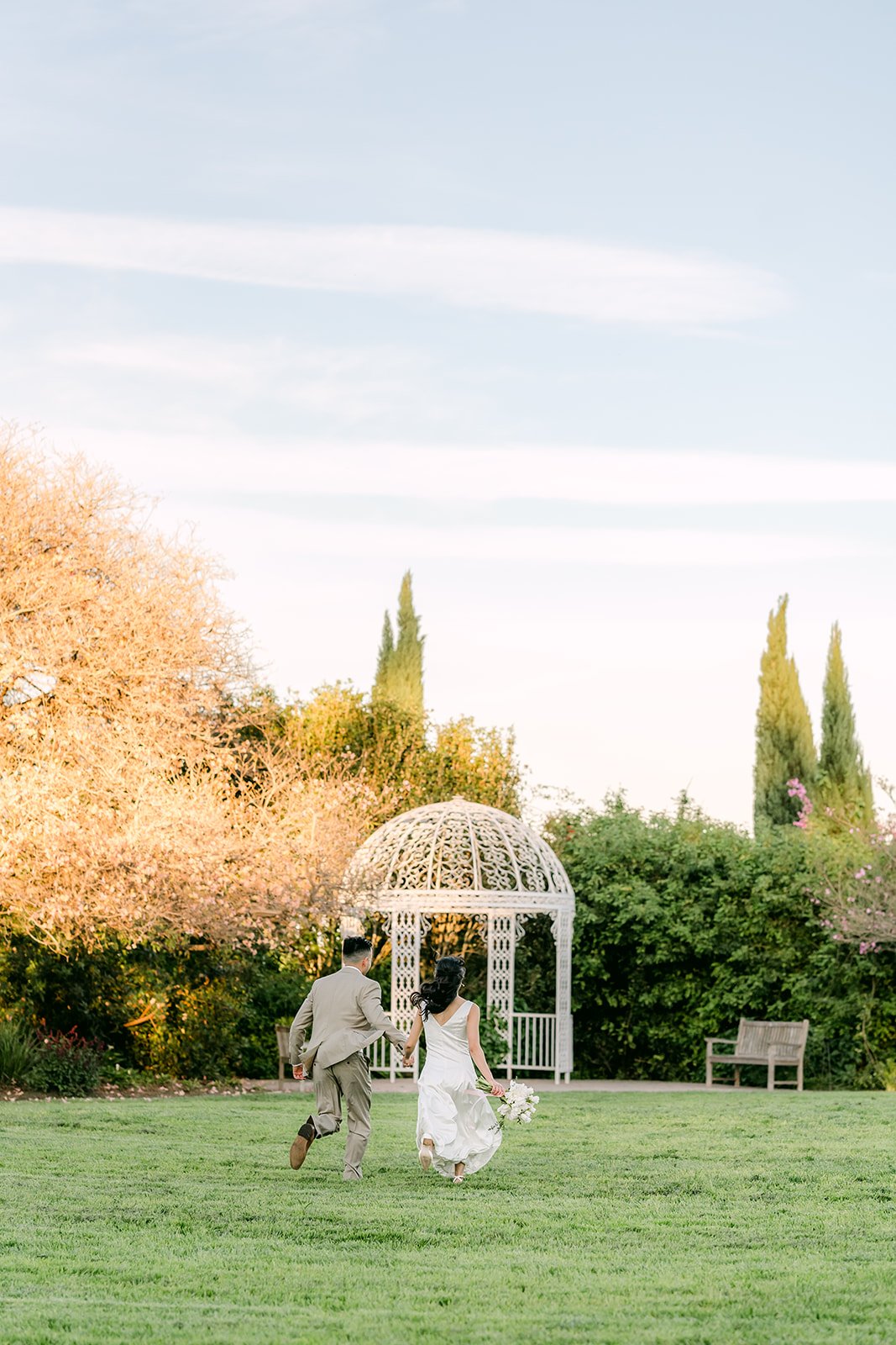 Wide view of the meadow with the white gazebo and cypress trees at South Coast Botanic Garden.