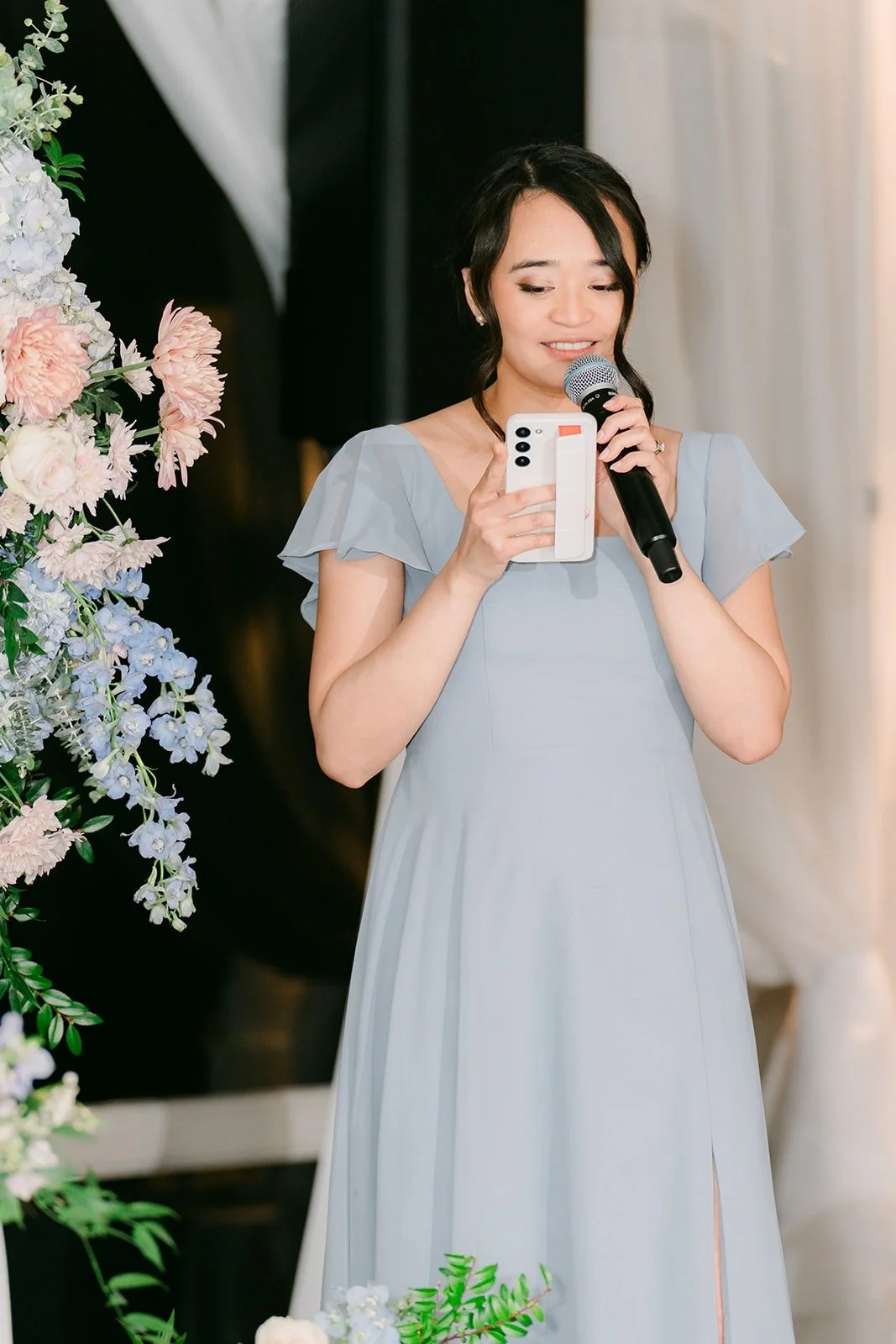 A bridesmaid giving a toast in dusty blue