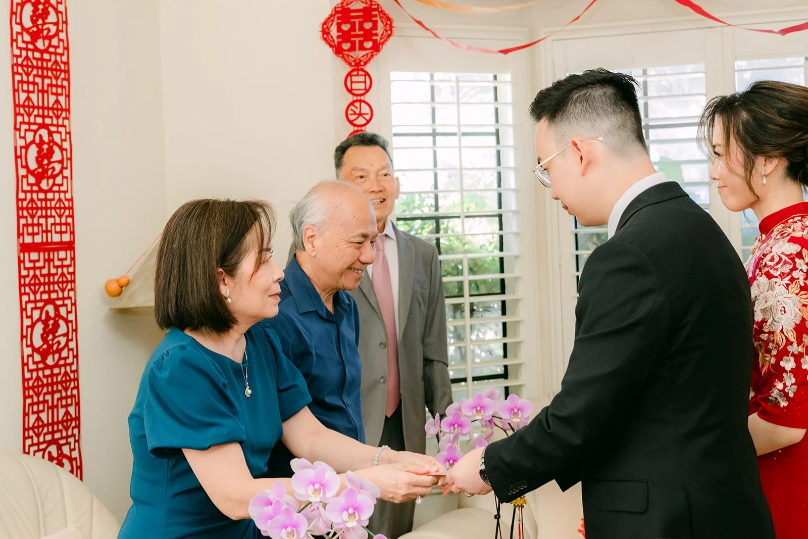 Pauline and Ken serving tea to an elder couple.