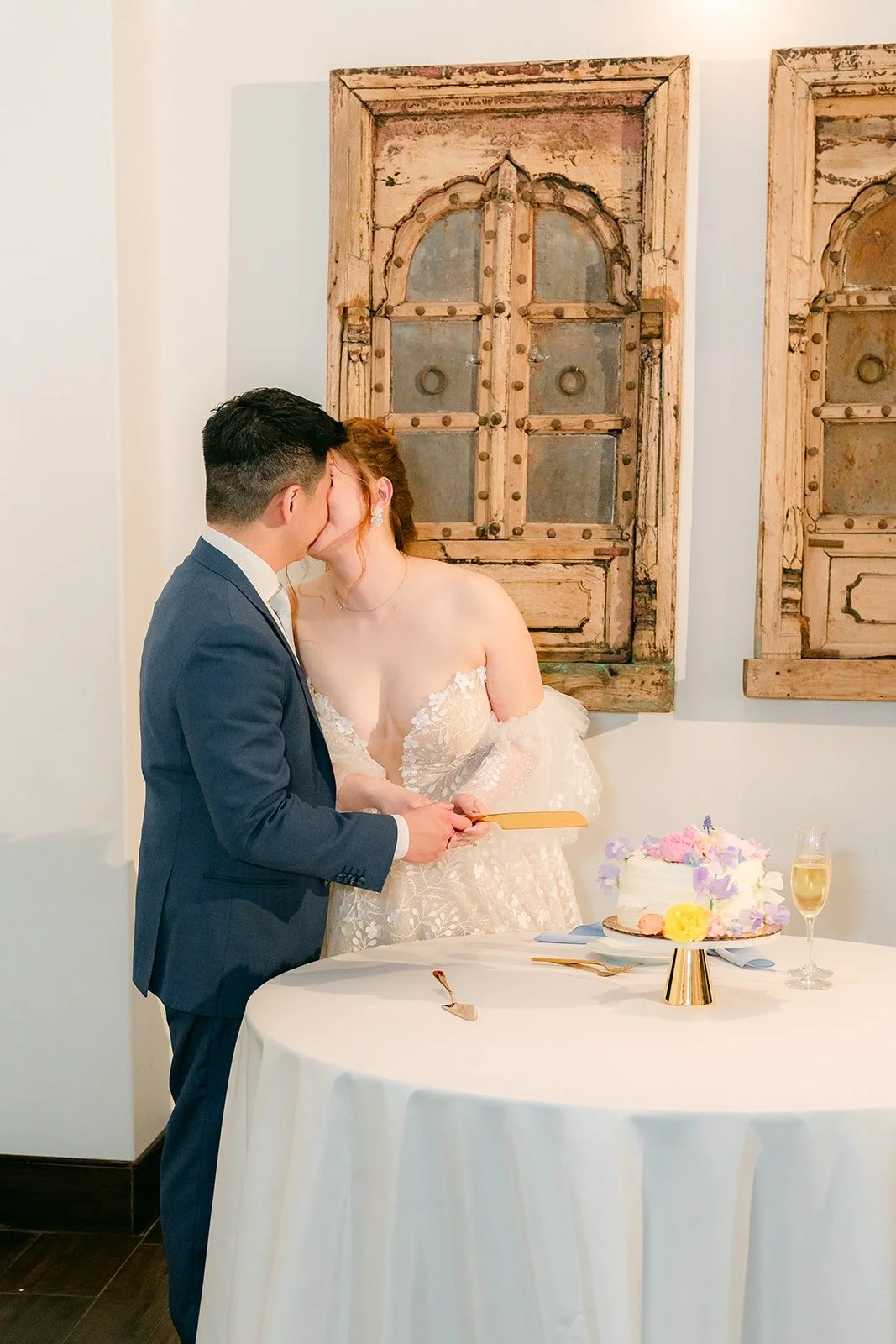 Joanna and Jerrick sharing a kiss before cutting the cake