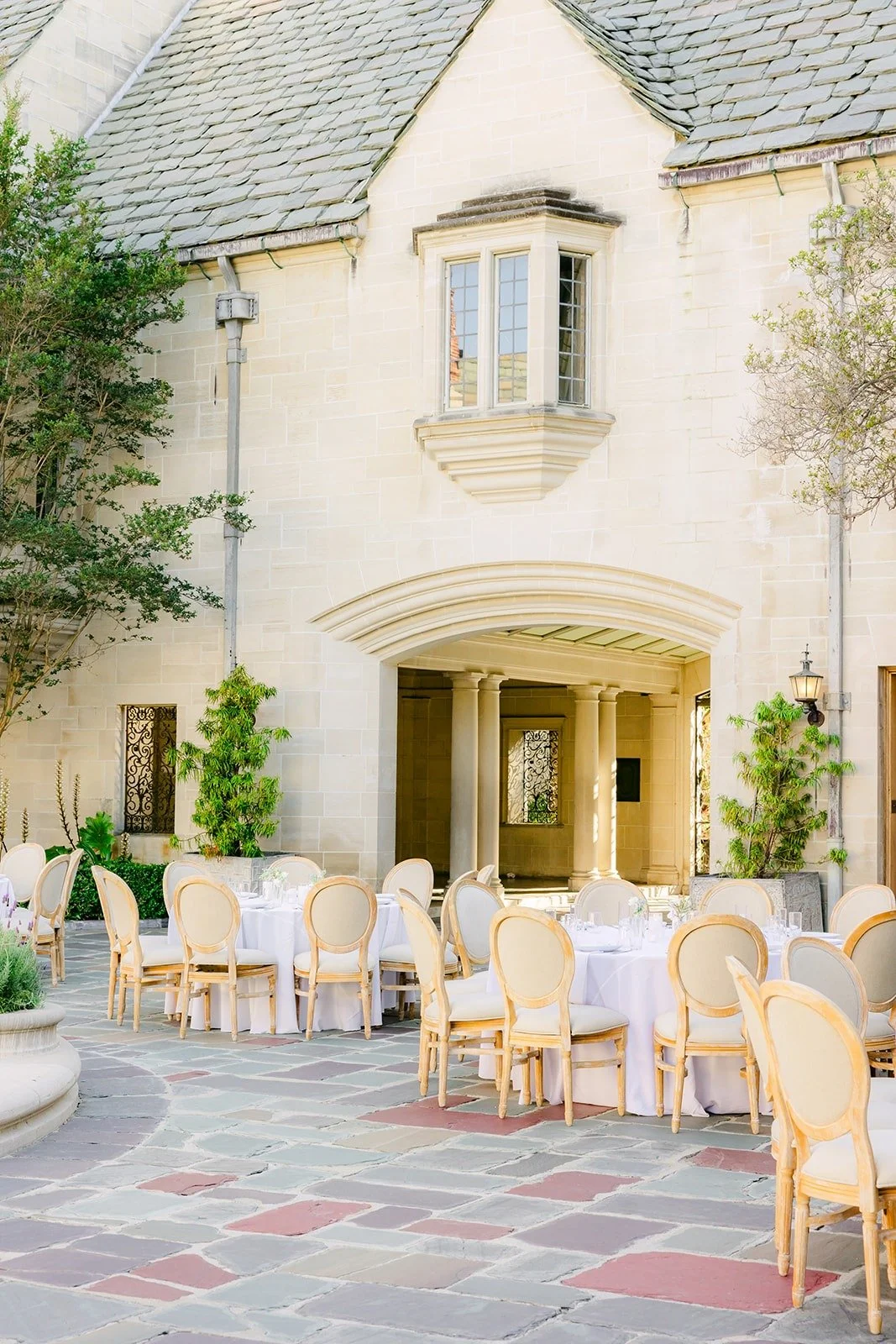 The courtyard set for dinner below the mansion windows
