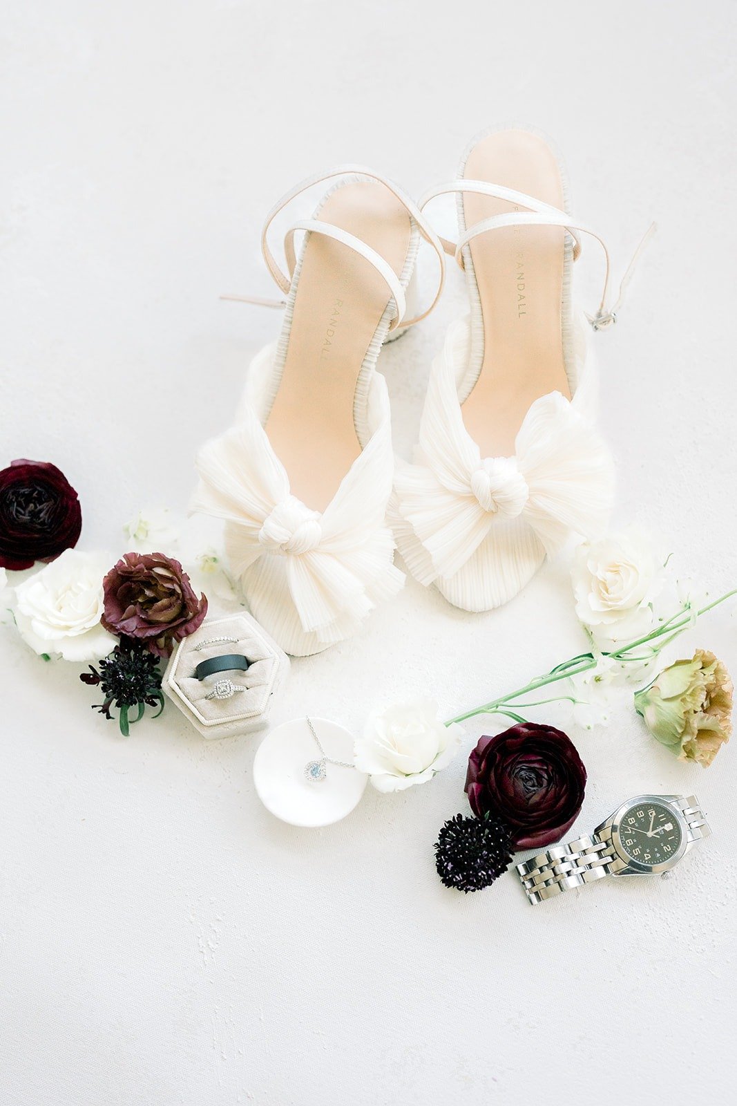 Betsy's white bow heels styled with burgundy blooms