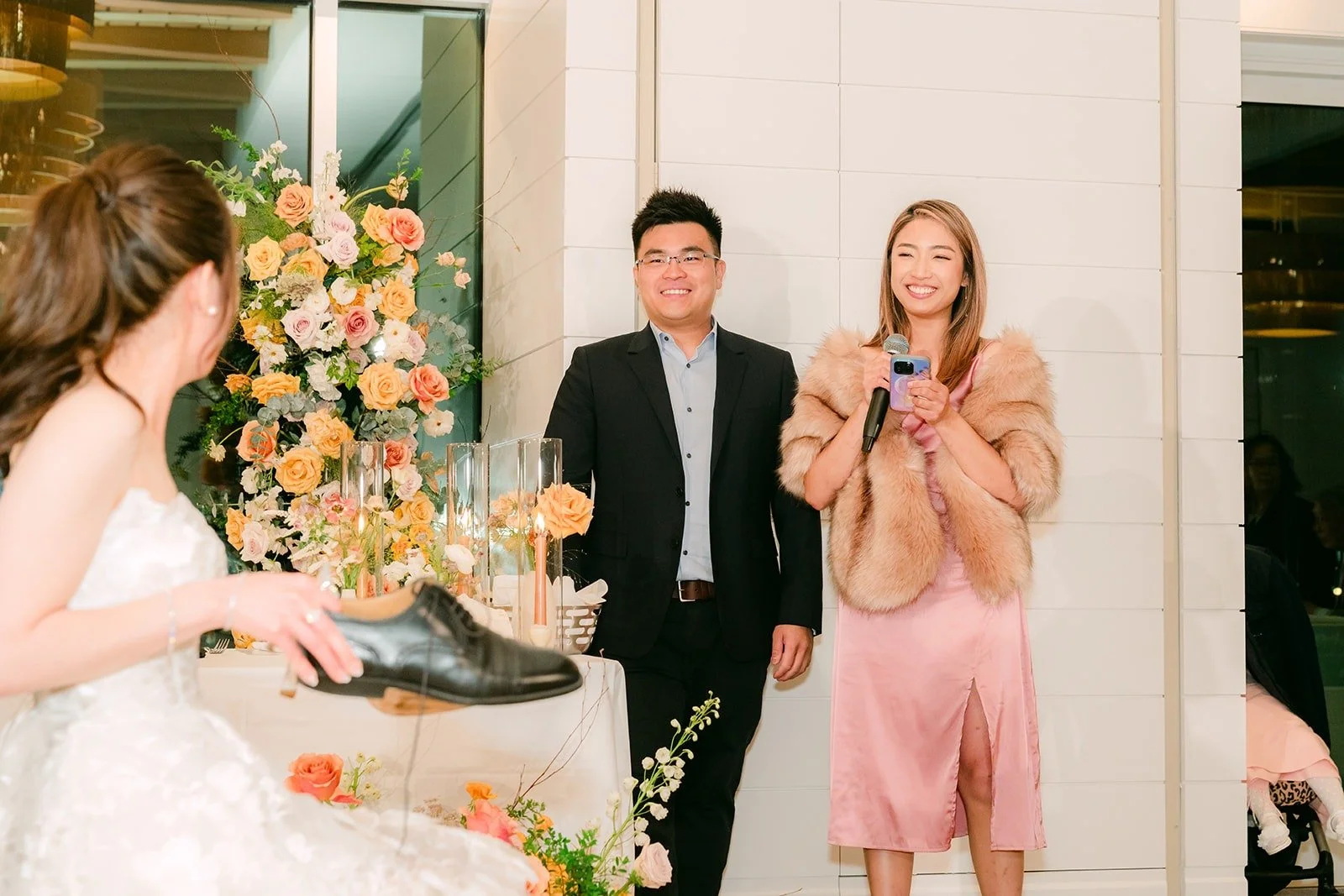 Angela and Eli laughing with guests during a game in the ballroom