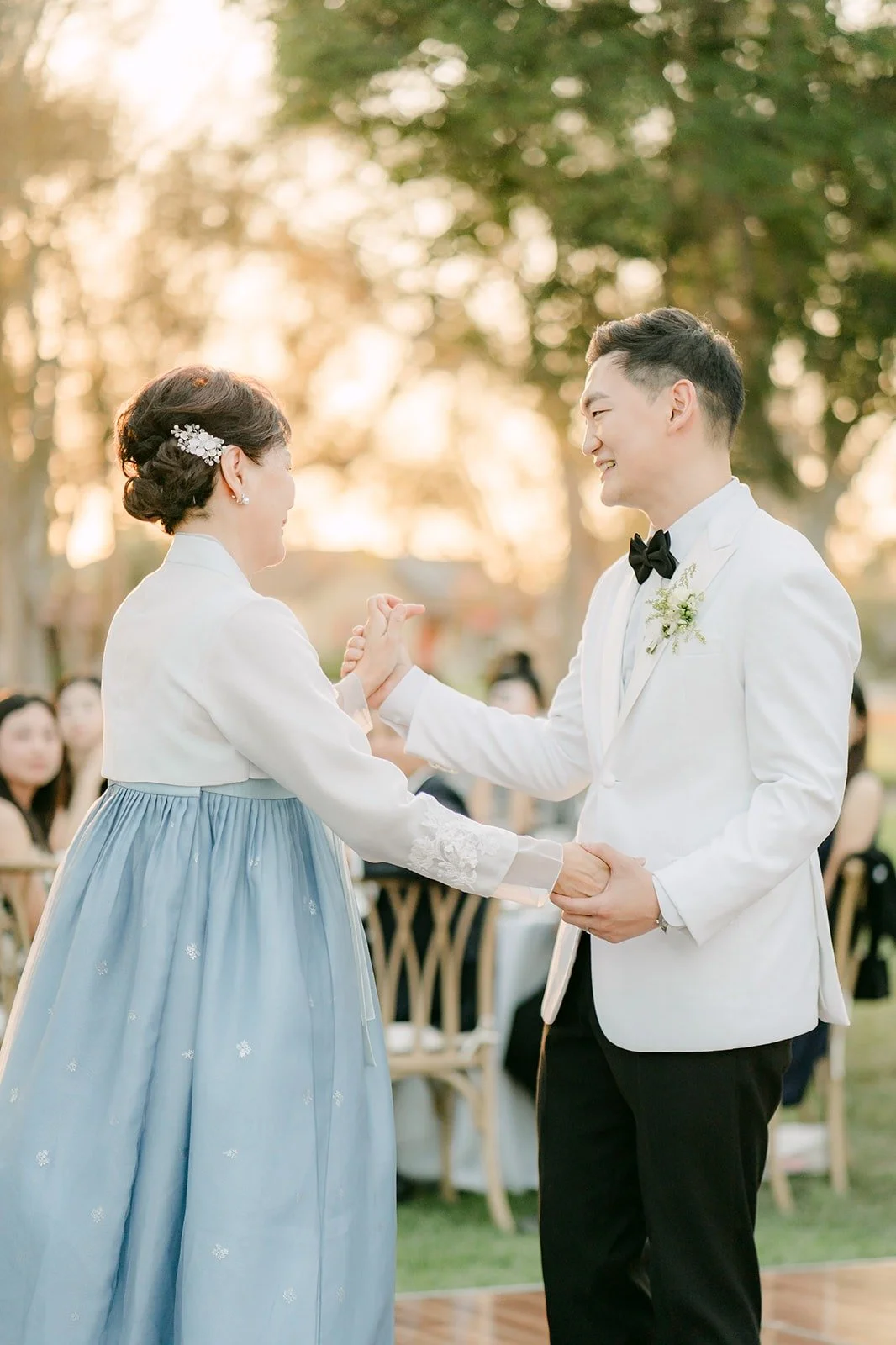 Sam dancing with his mom in a blue hanbok