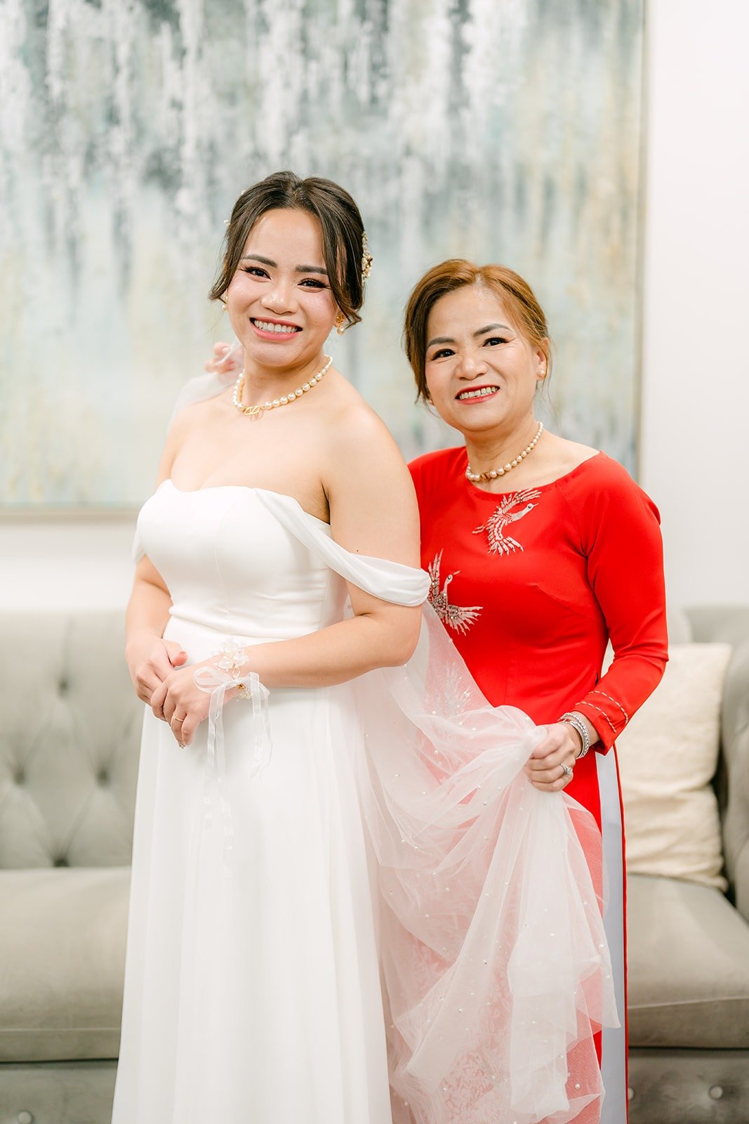 A family member in red fixing Ivy's gown in the bridal suite